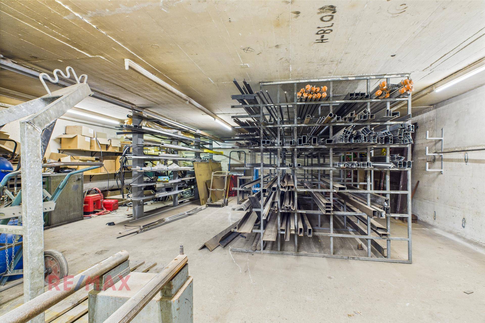Lagerraum oder Werkstatt mit Metallregalen voller Profile und Materialien.