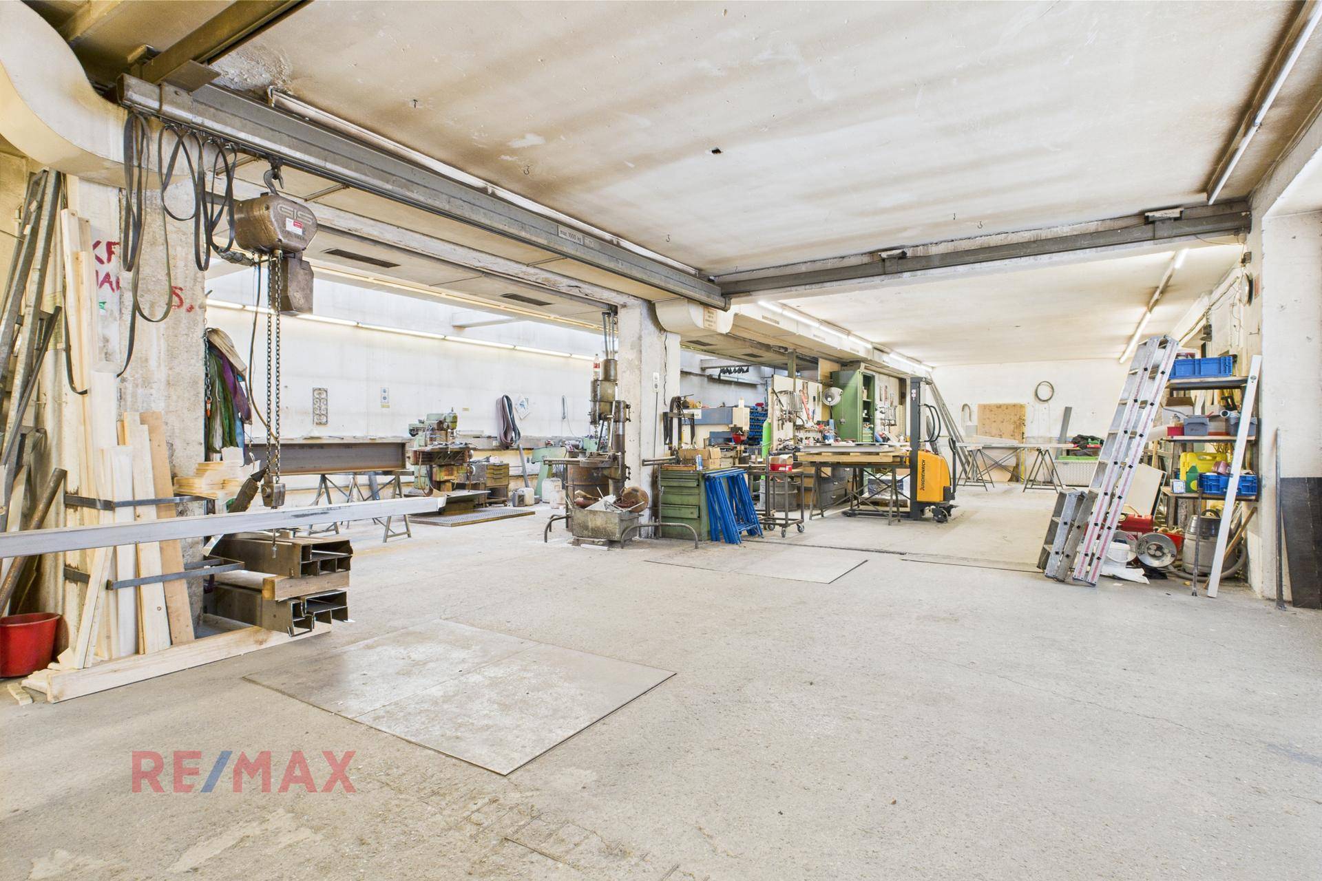 Große Werkstatt mit Kranbahn, Maschinen und viel Platz für industrielle Arbeiten.