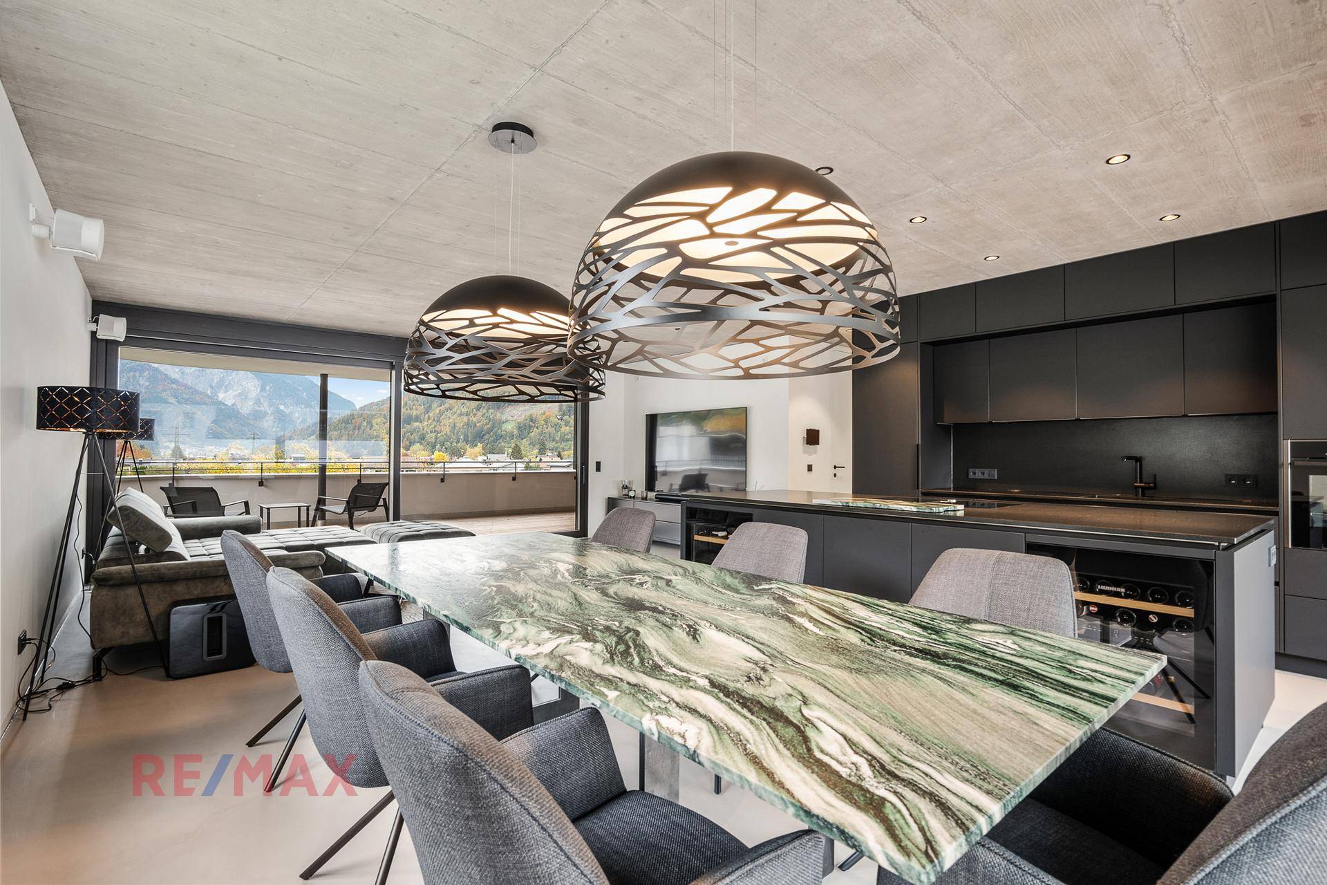 Eleganter Essbereich mit Marmortisch und offener Küche, ergänzt durch moderne Pendelleuchten.
