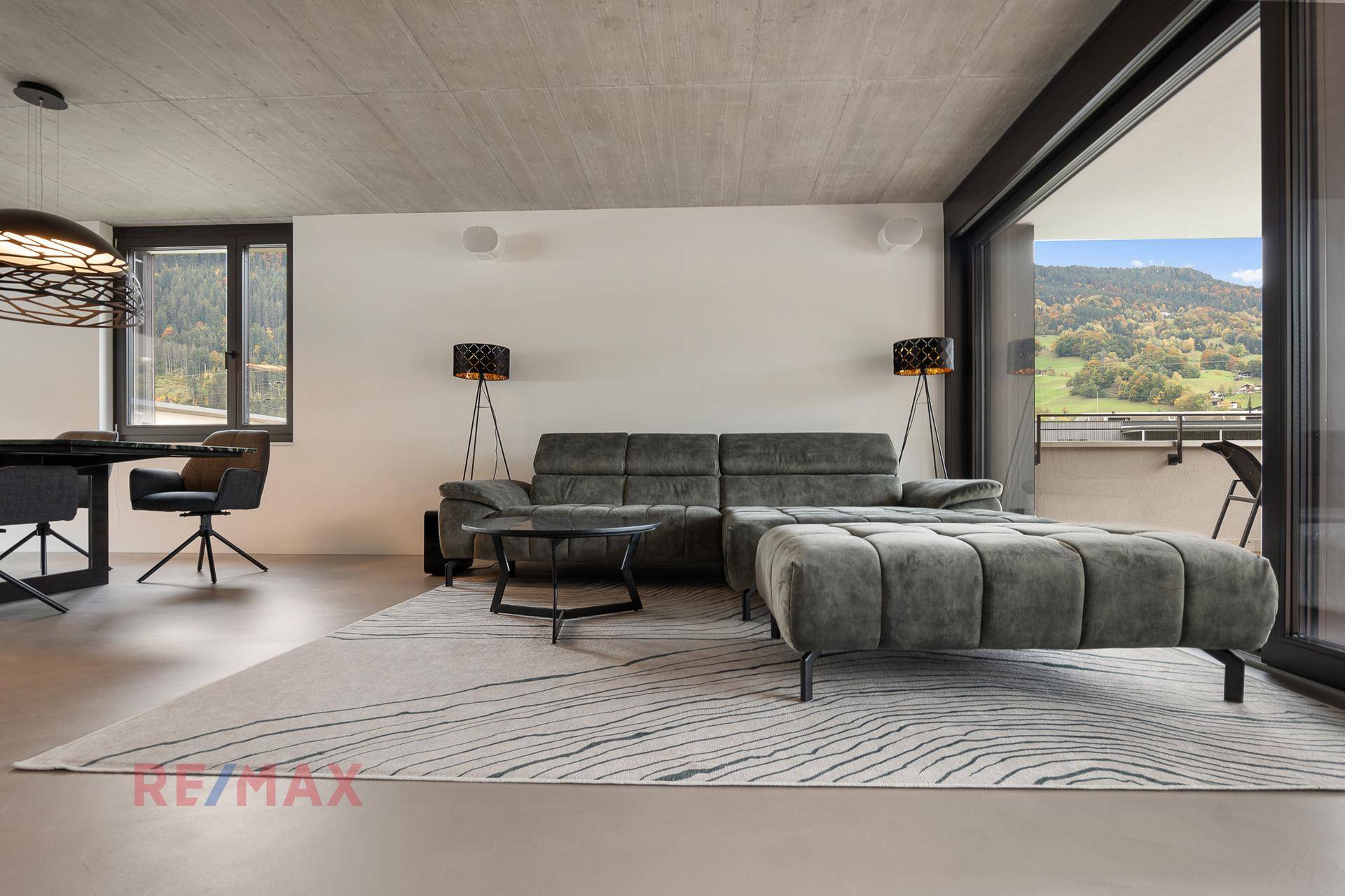 Gemütliches Wohnzimmer mit großem Sofa und Zugang zur Terrasse mit Bergblick.