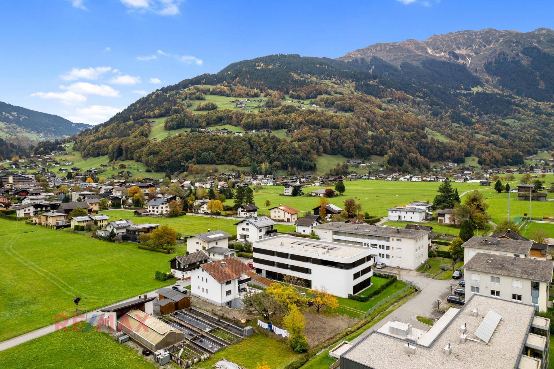 Panoramablick aus der Vogelperspektive auf die Siedlung und die umliegende Natur mit Bergen.