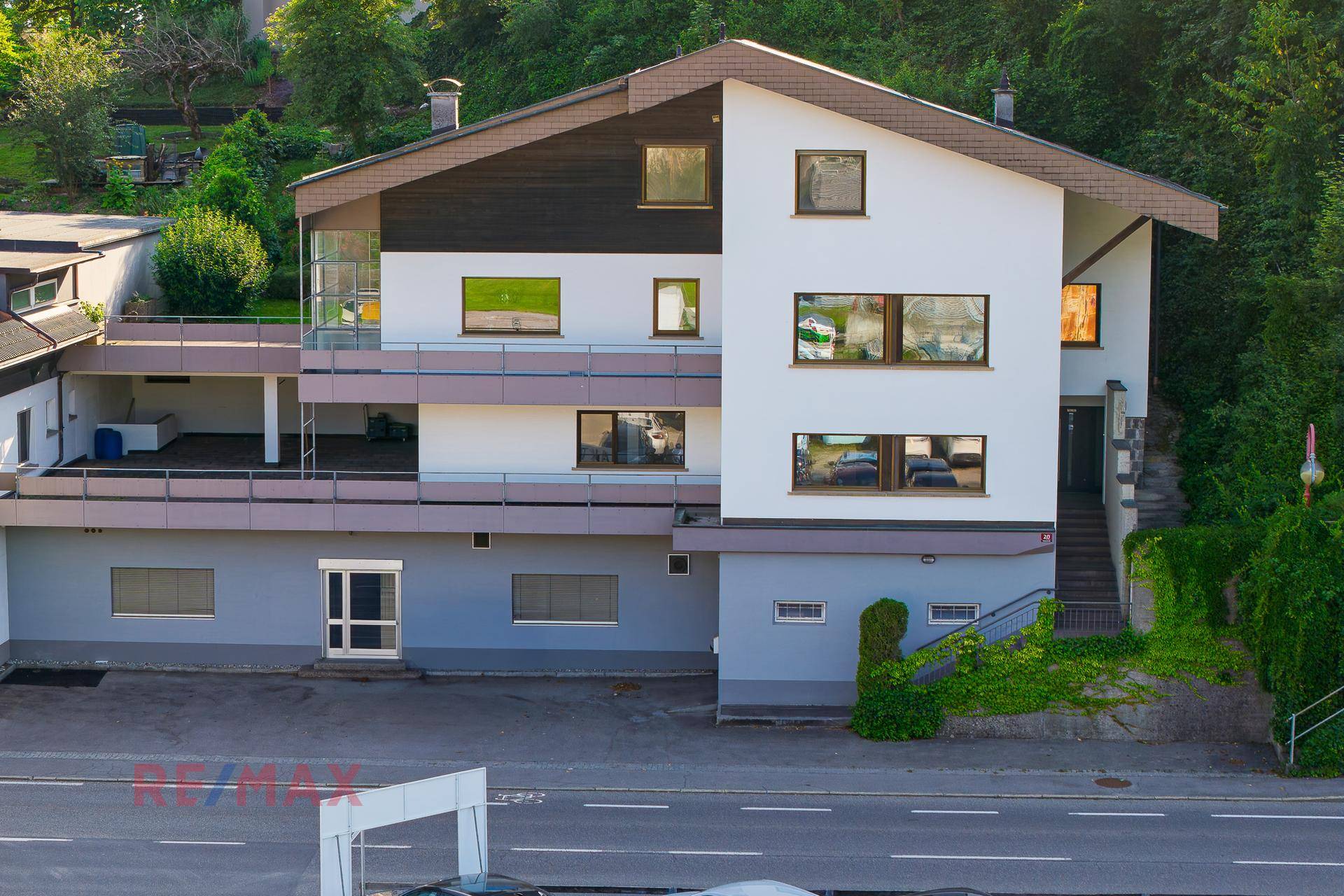 Mehrstöckiges Gebäude mit Balkonen und moderner Architektur an einer Straße gelegen.