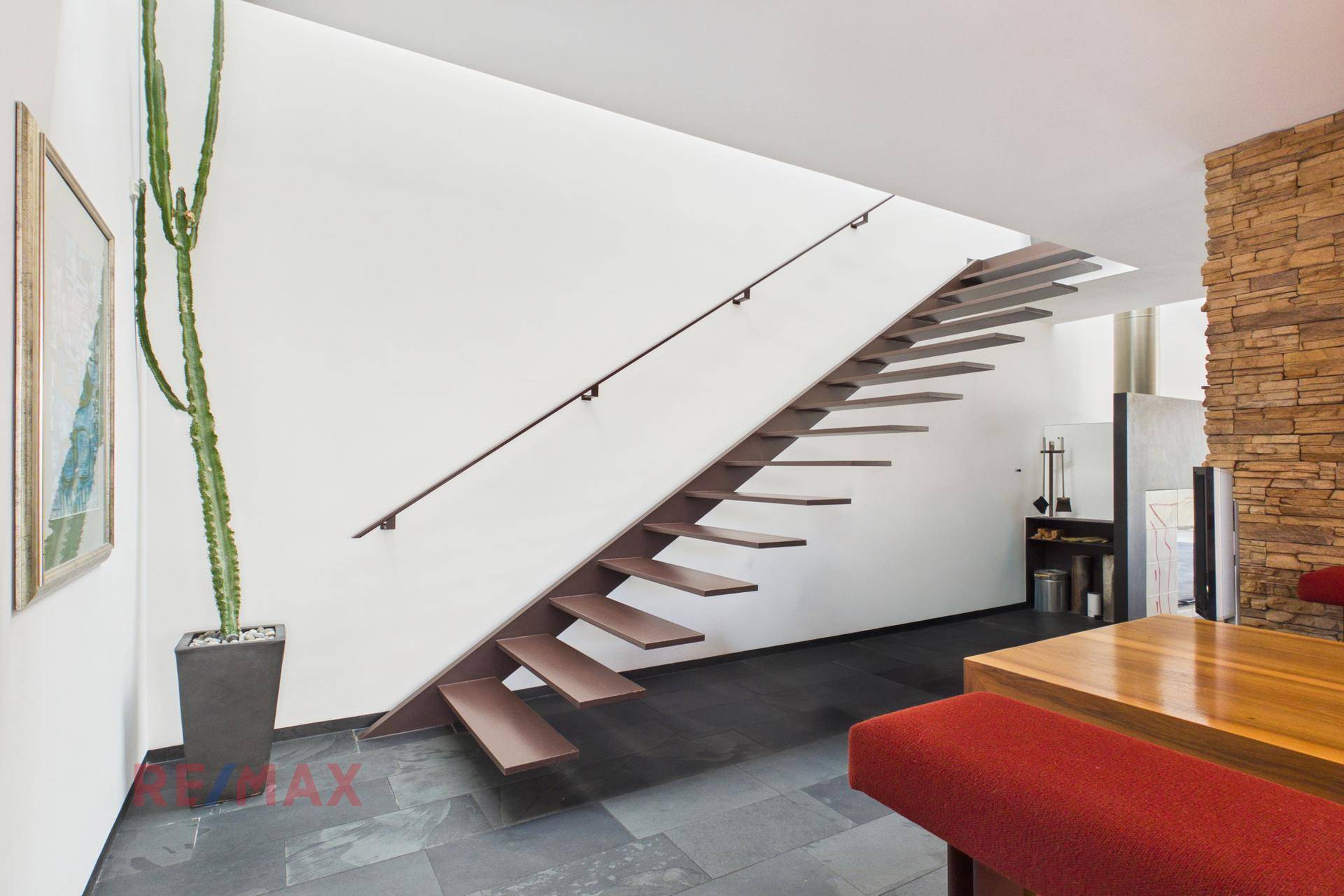 Elegante schwebende Treppe mit Holzstufen und modernem Design im Eingangsbereich.