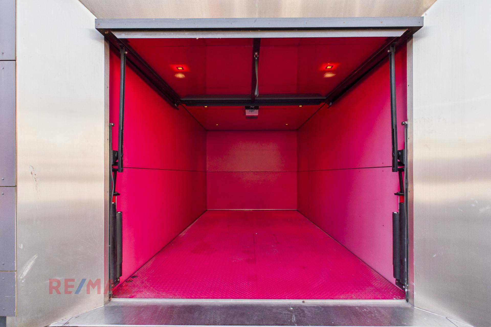 Innenansicht eines modernen Autolifts mit leuchtend roter Auskleidung.