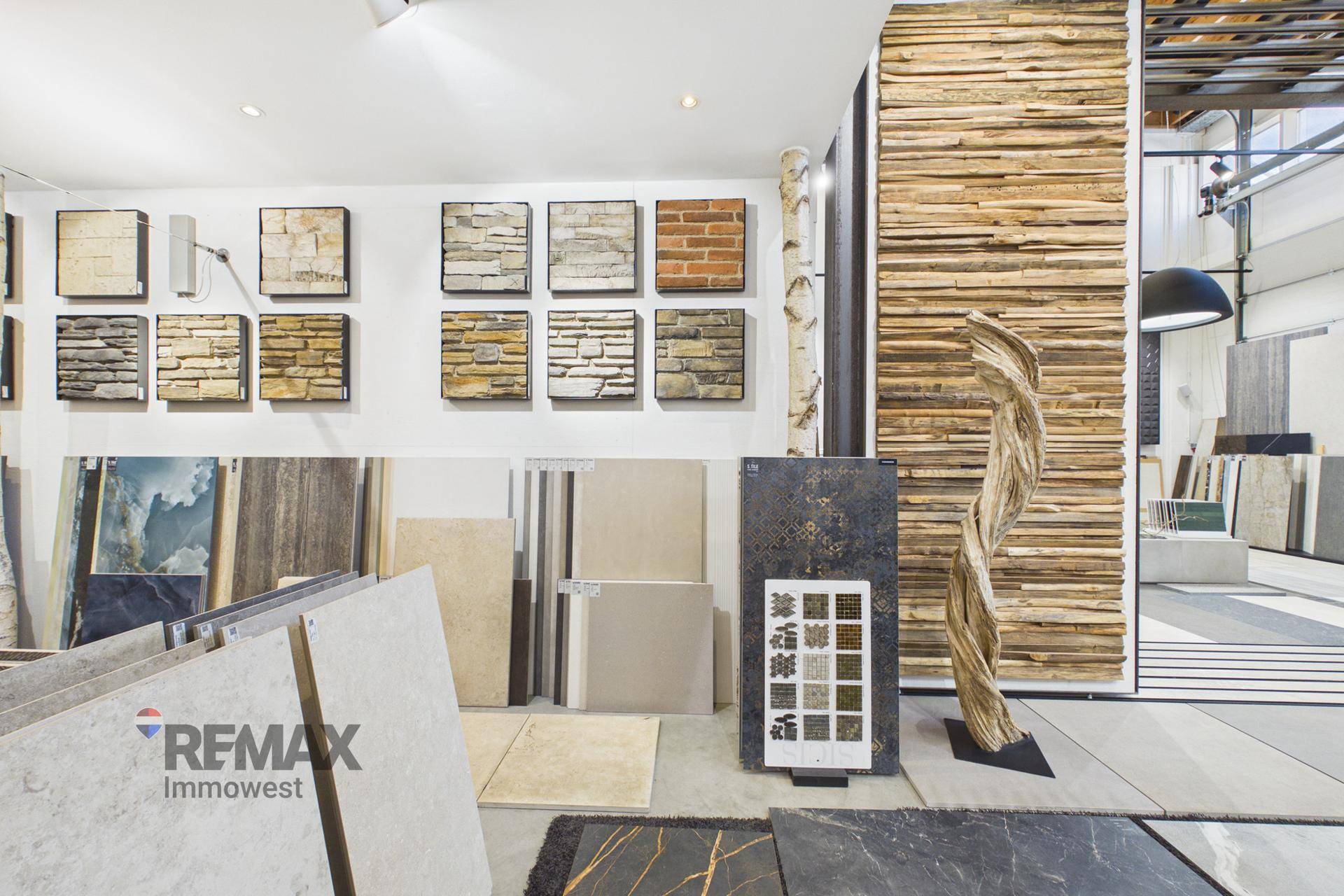Fliesenausstellung mit Wandverkleidungsmustern und einer dekorativen Holzskulptur in hellem Ambiente.