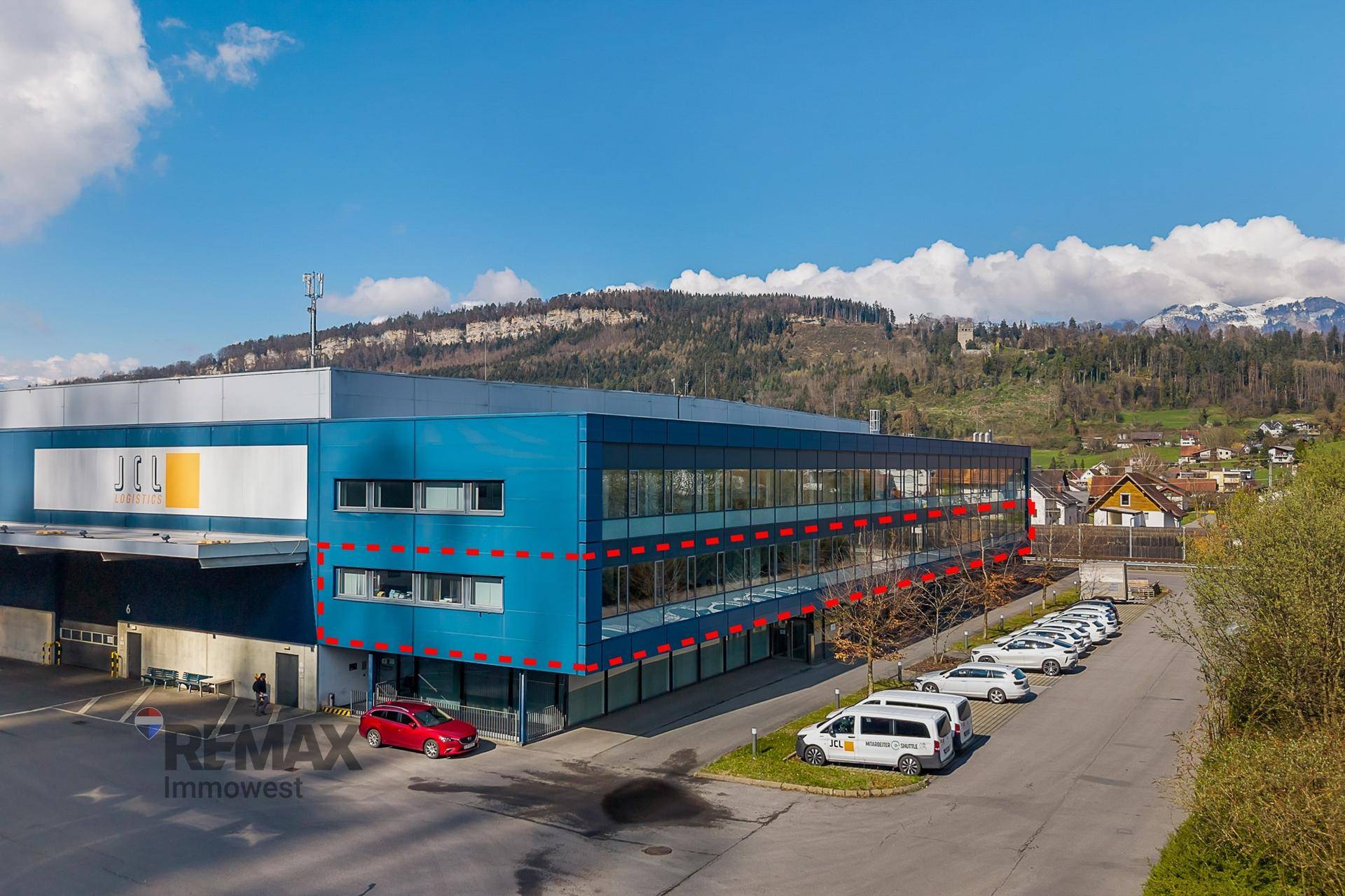 Ansicht des modernen Bürogebäudes mit blauer Fassade und großen Fenstern.