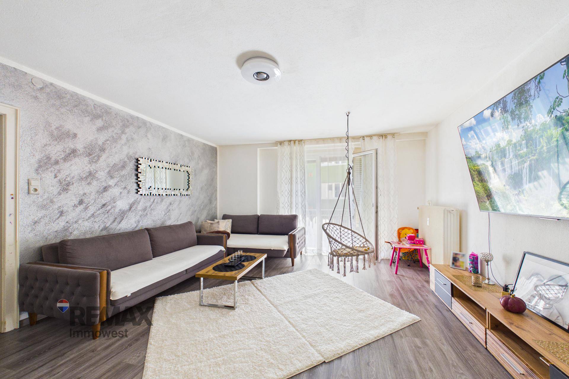 Helles Wohnzimmer mit modernem Dekor, Laminatboden und Zugang zum Balkon.