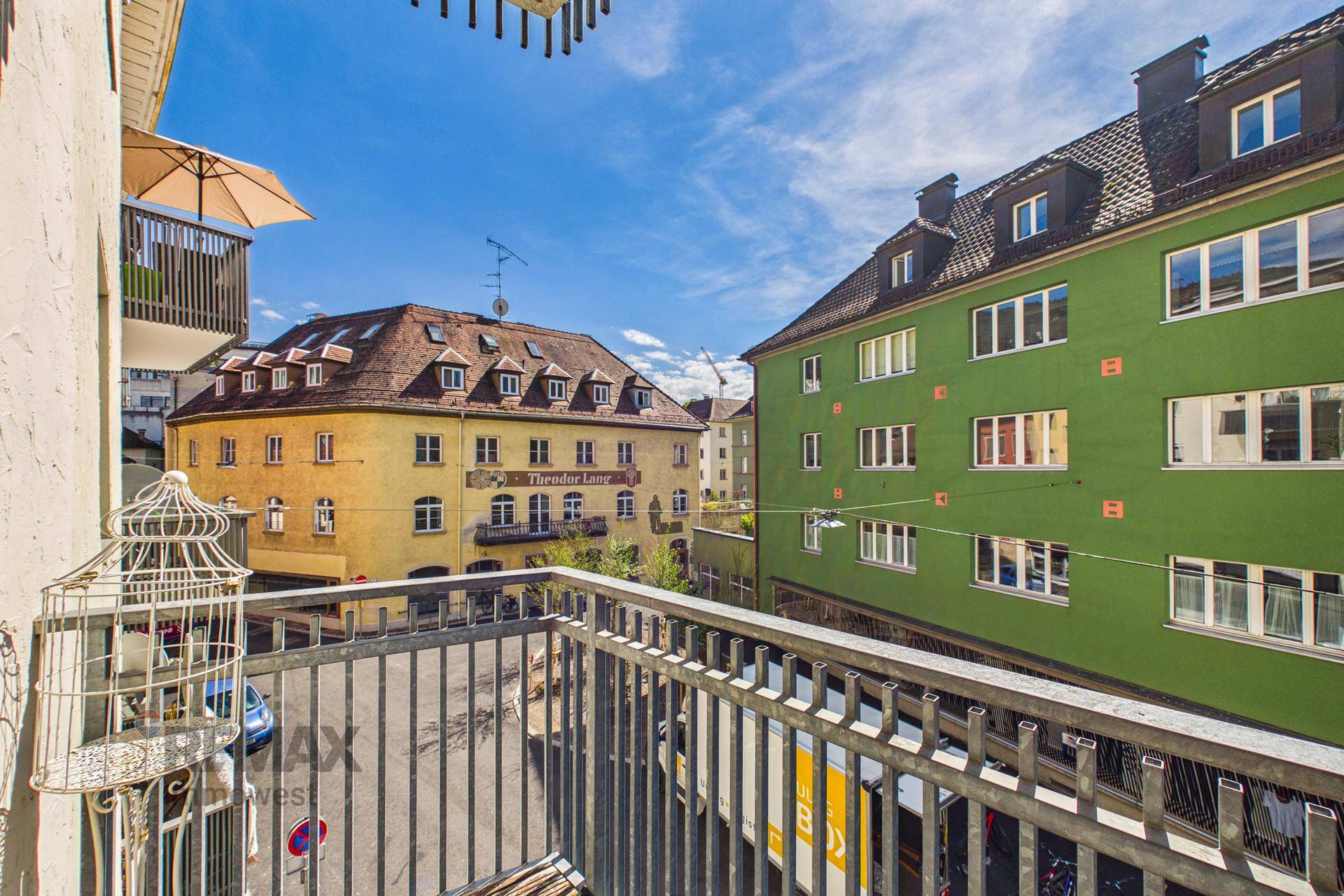 Balkon mit Blick auf die Straße und umliegende Gebäude in der Stadt.