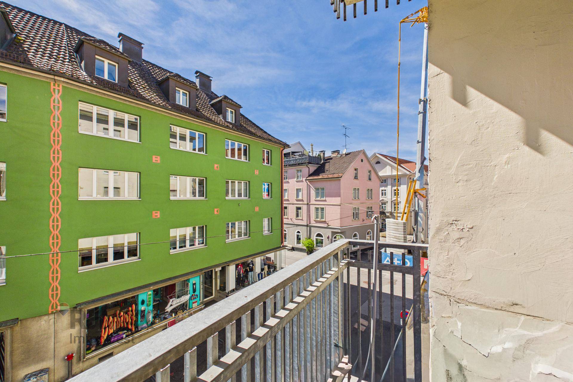 Balkon mit urbanem Ausblick auf die Straße und angrenzende Gebäude.