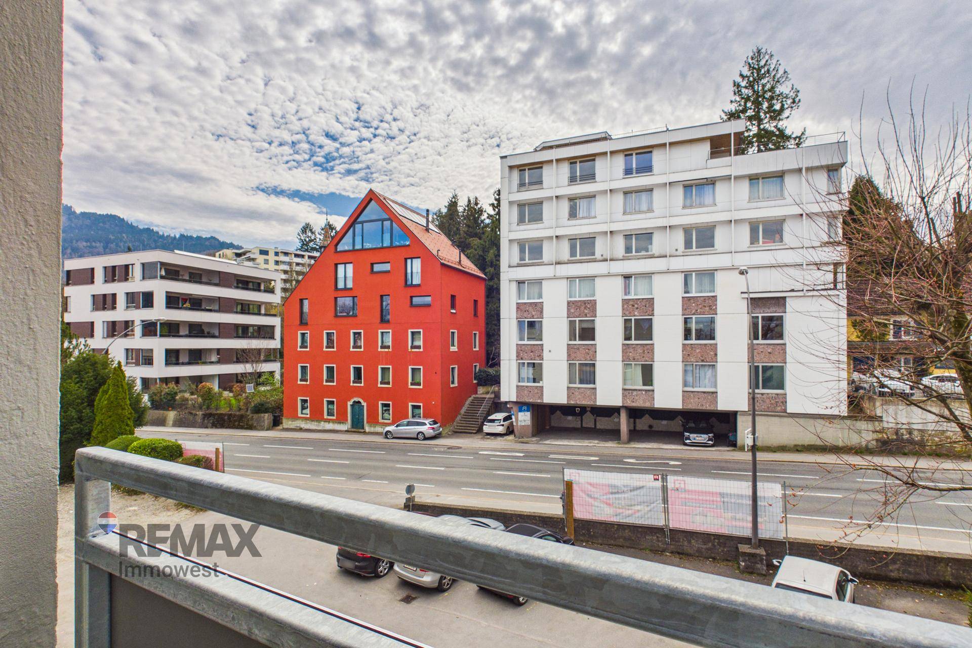 Weitblick vom Balkon auf die Straße und die umliegende Bebauung.