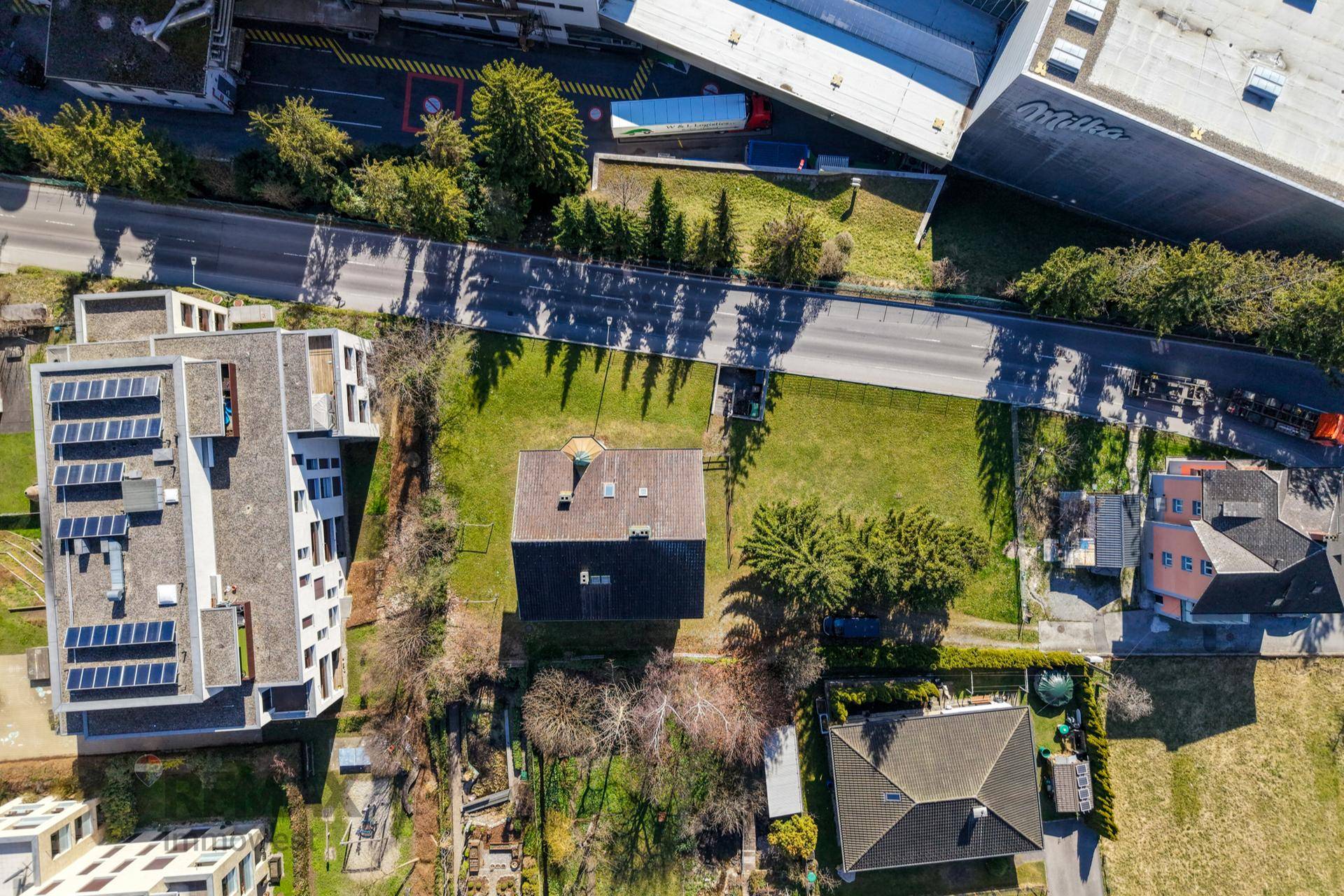 Luftaufnahme des Grundstücks mit dem Gebäude, umgeben von Bäumen und angrenzenden Straßen.