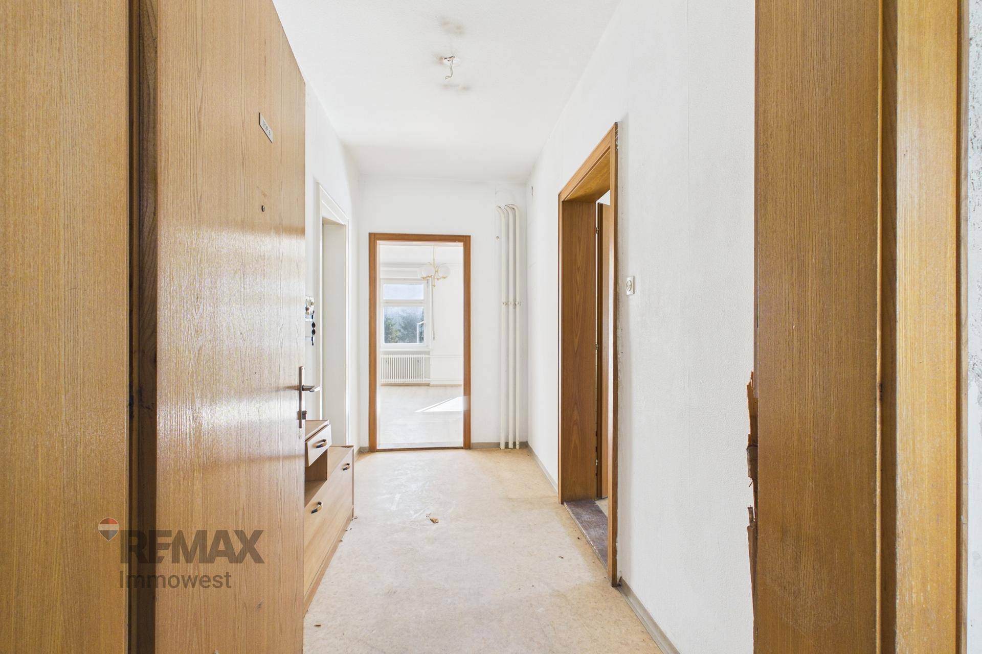Langer Flur mit Holztüren und Blick in angrenzende Zimmer.