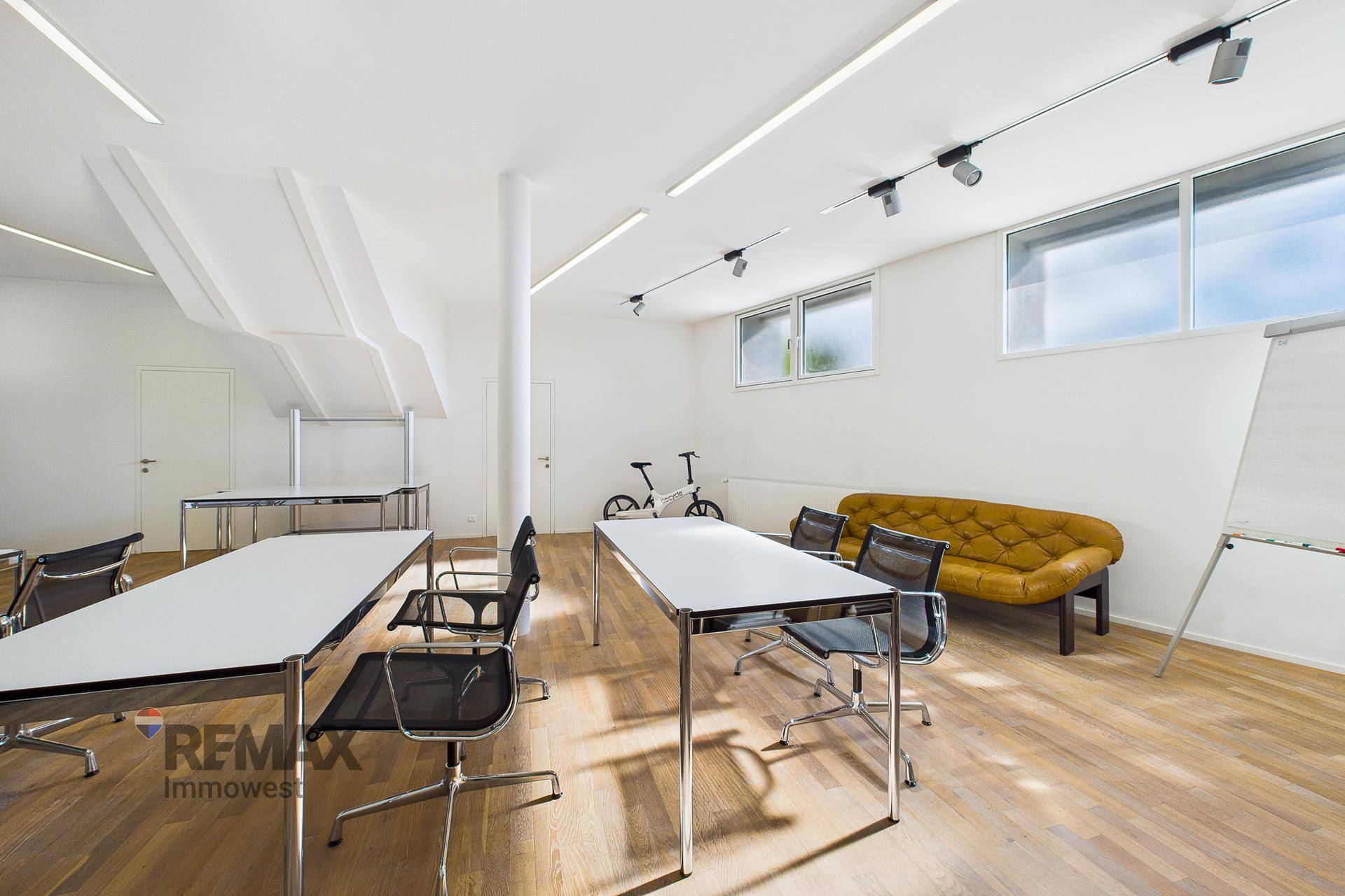 Geräumiger Konferenzraum mit Holzboden, flexibler Bestuhlung und viel Tageslicht, perfekt für Workshops.