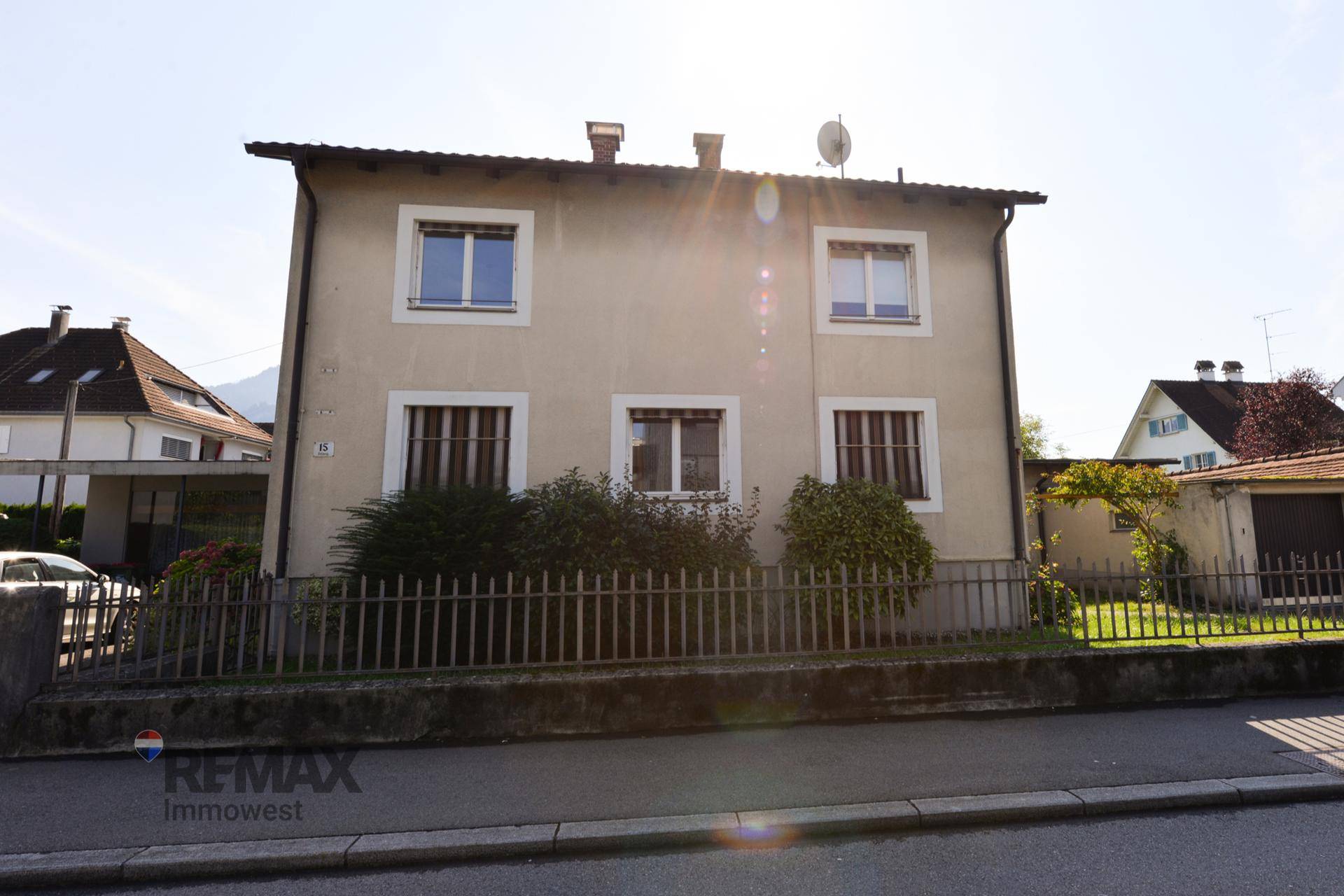 Vorderansicht des Hauses von der Straße mit kleinem Vorgarten und einem Zaun.