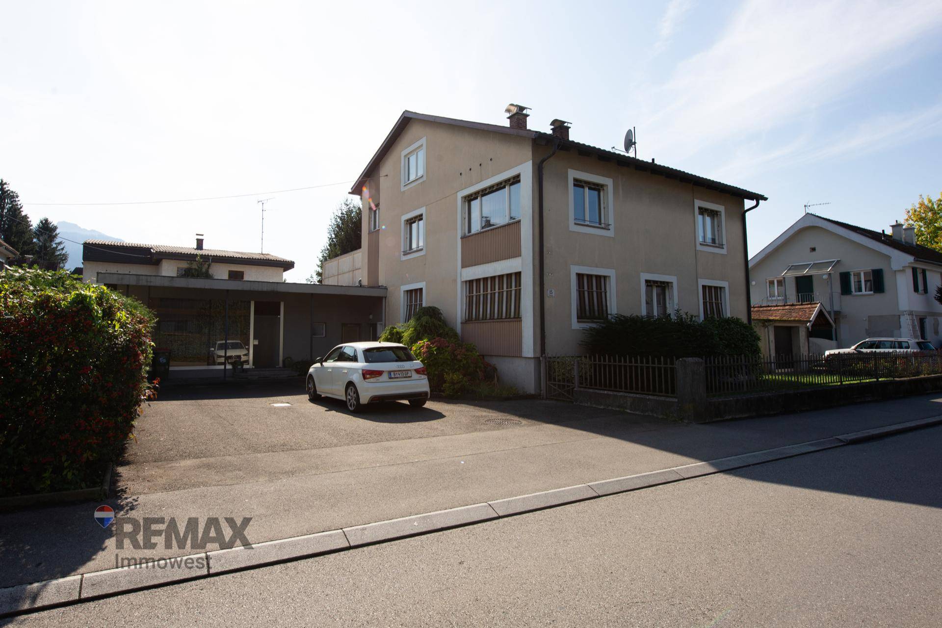 Seitenansicht des Hauses mit einem Carport und der Zufahrt von der Straße.