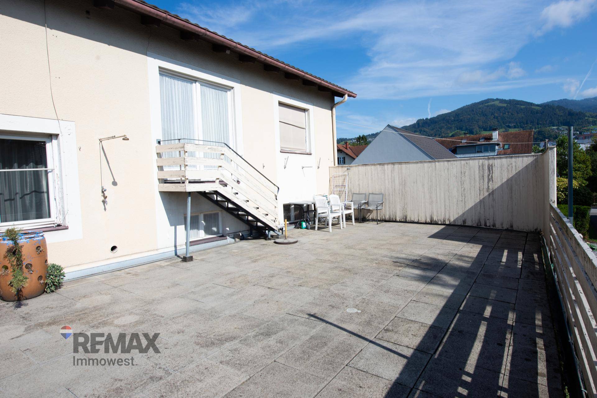 Weitläufige Terrasse mit Blick auf die umliegende Landschaft und die Berge im Hintergrund.