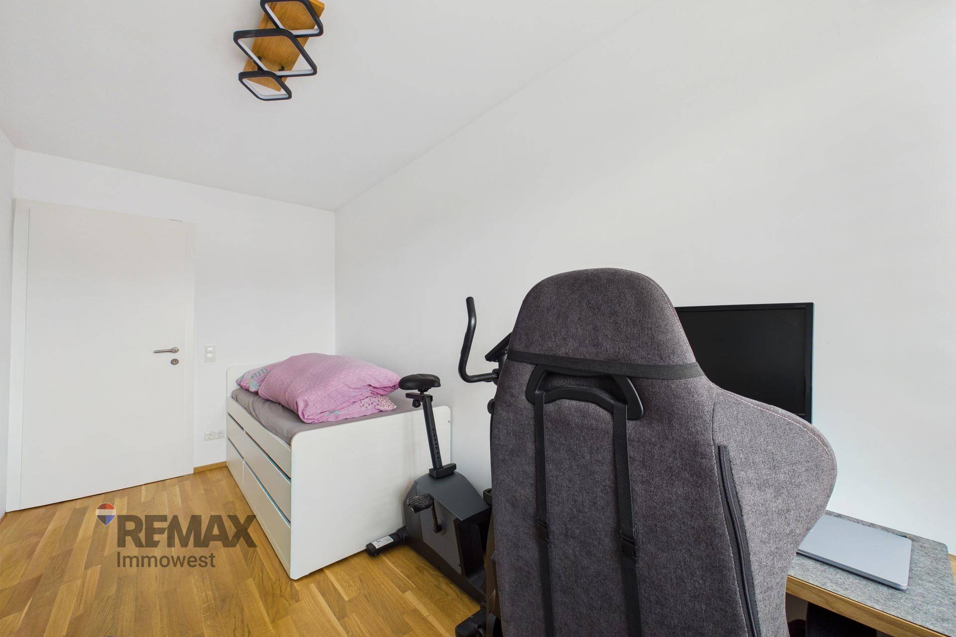 Schlafzimmer mit Einzelbett, Schreibtisch und Blick auf die umliegende Landschaft.