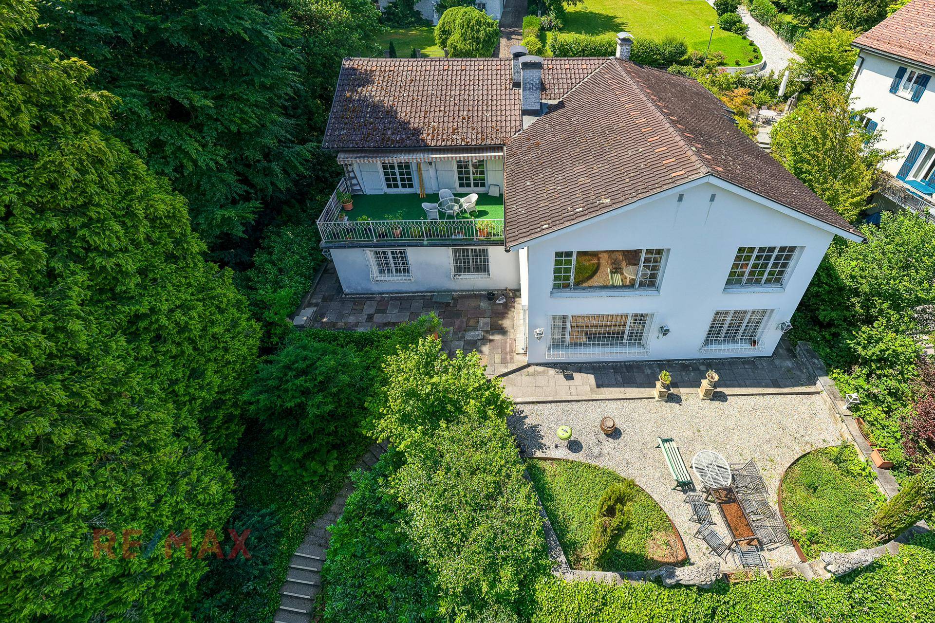 Luftaufnahme der Villa mit großem Garten, Terrassen und umgebender grüner Landschaft.