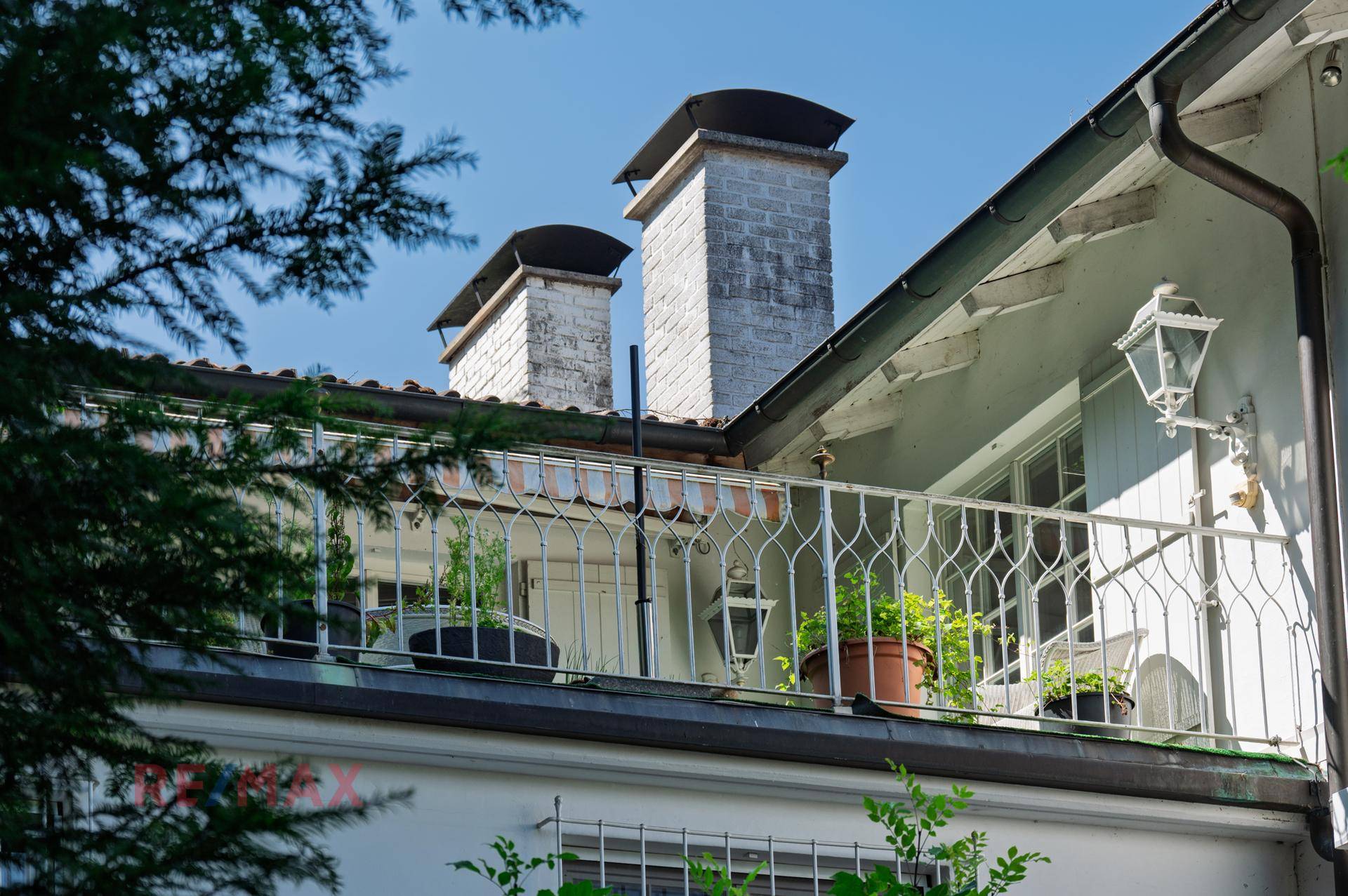 Kleiner Balkon mit schmiedeeisernem Geländer und Blick auf die Umgebung.