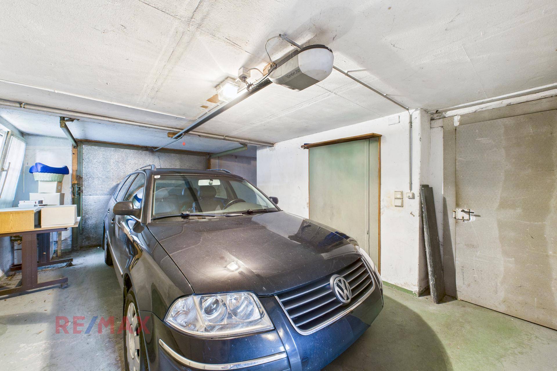 Geräumige Garage mit einem geparkten Auto und Stauraum an den Seitenwänden.
