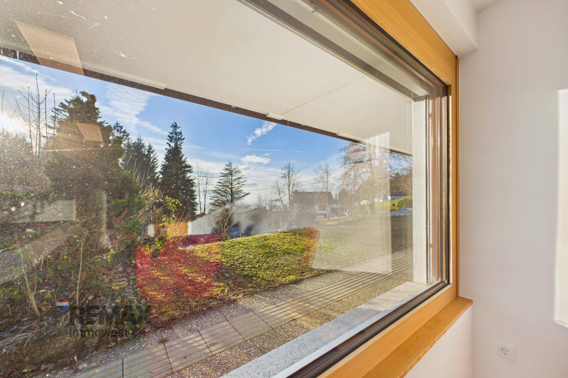 Große Fensterfront bietet einen schönen Blick auf die grüne Umgebung und die umliegenden Häuser.