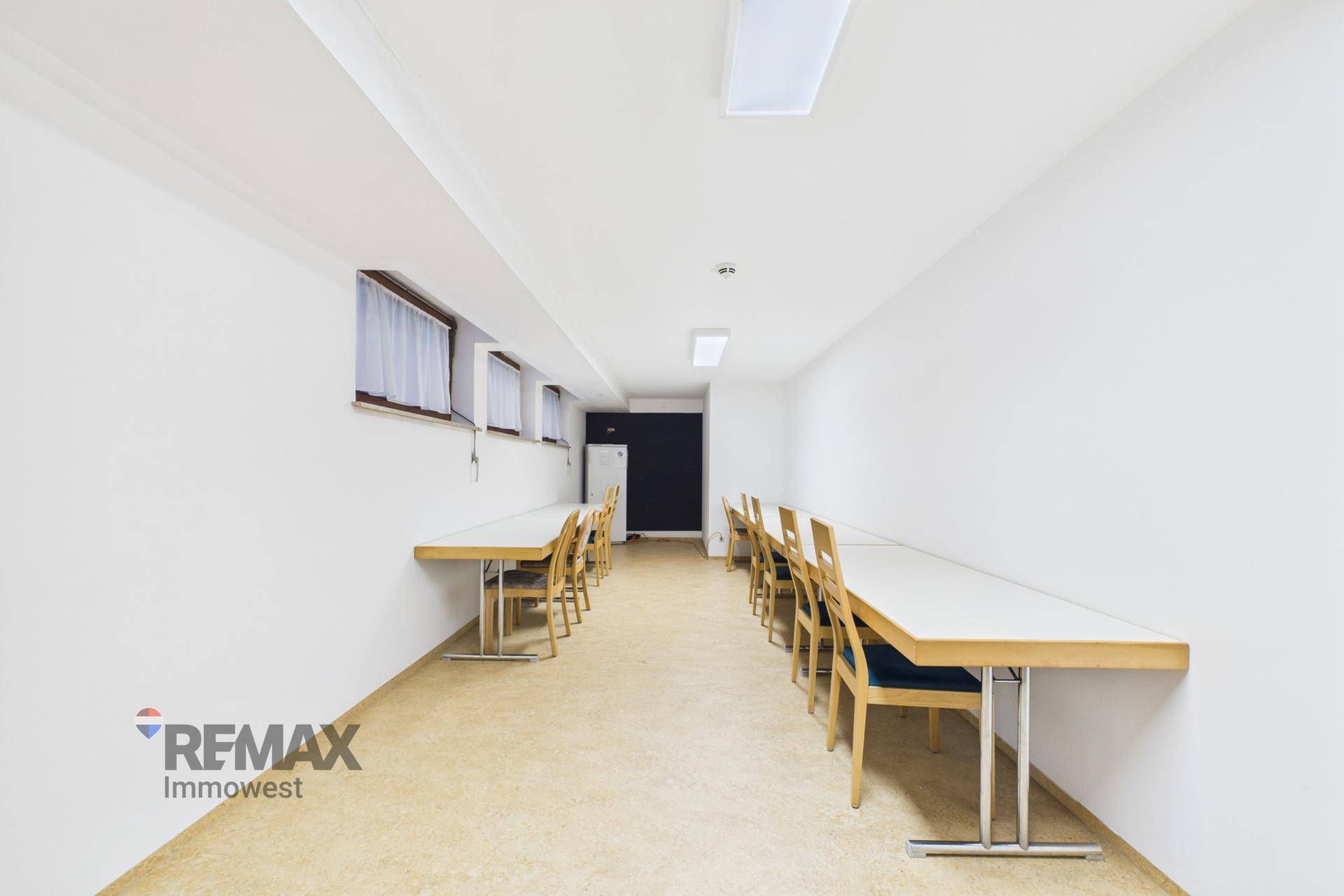 Heller Unterrichtsraum mit Reihen von Tischen und Stühlen, ideal für Schulungen oder Workshops.