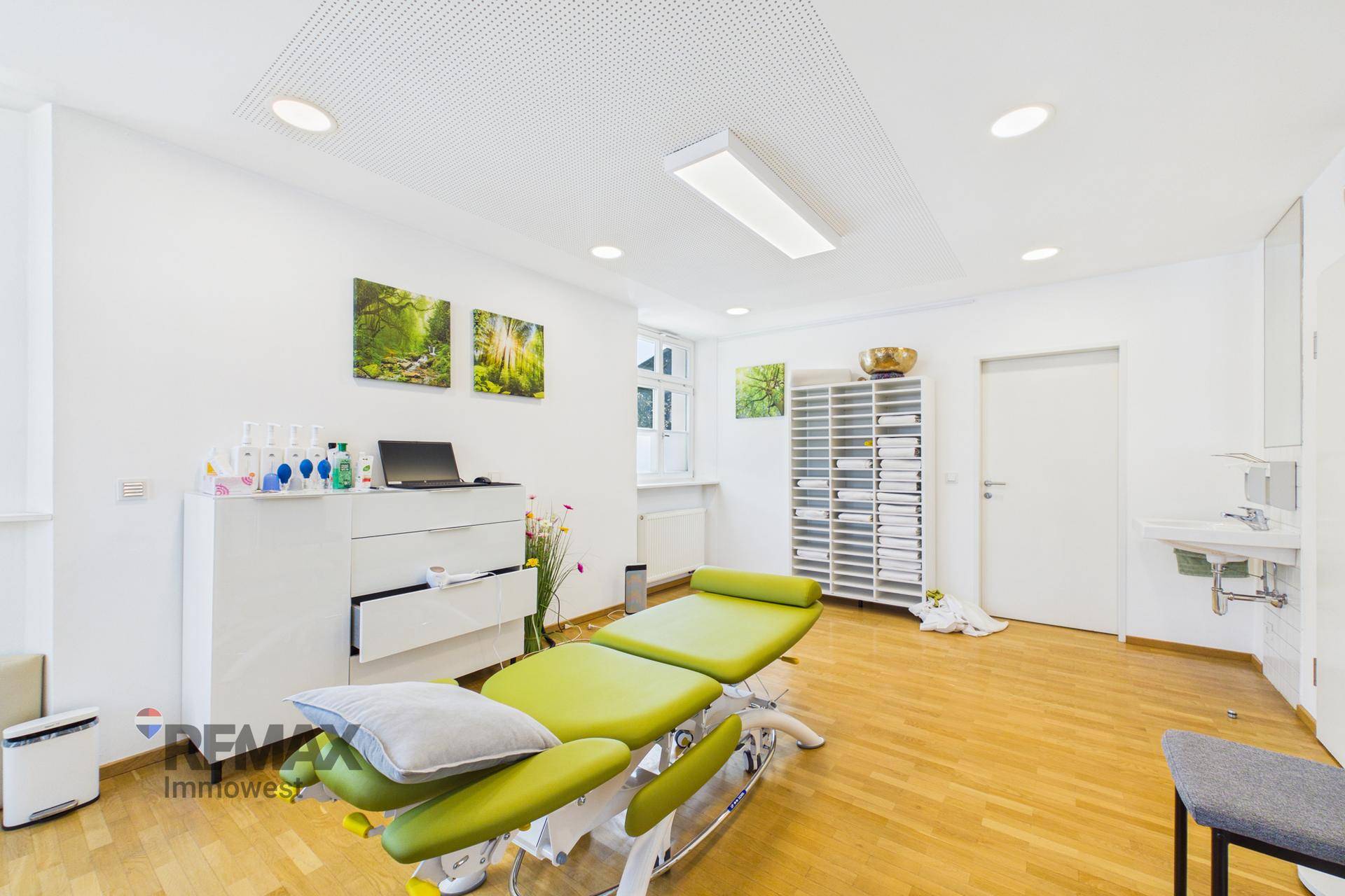 Funktioneller Therapieraum mit Behandlungsliege, Stauraum und Waschbecken, hell und sauber.