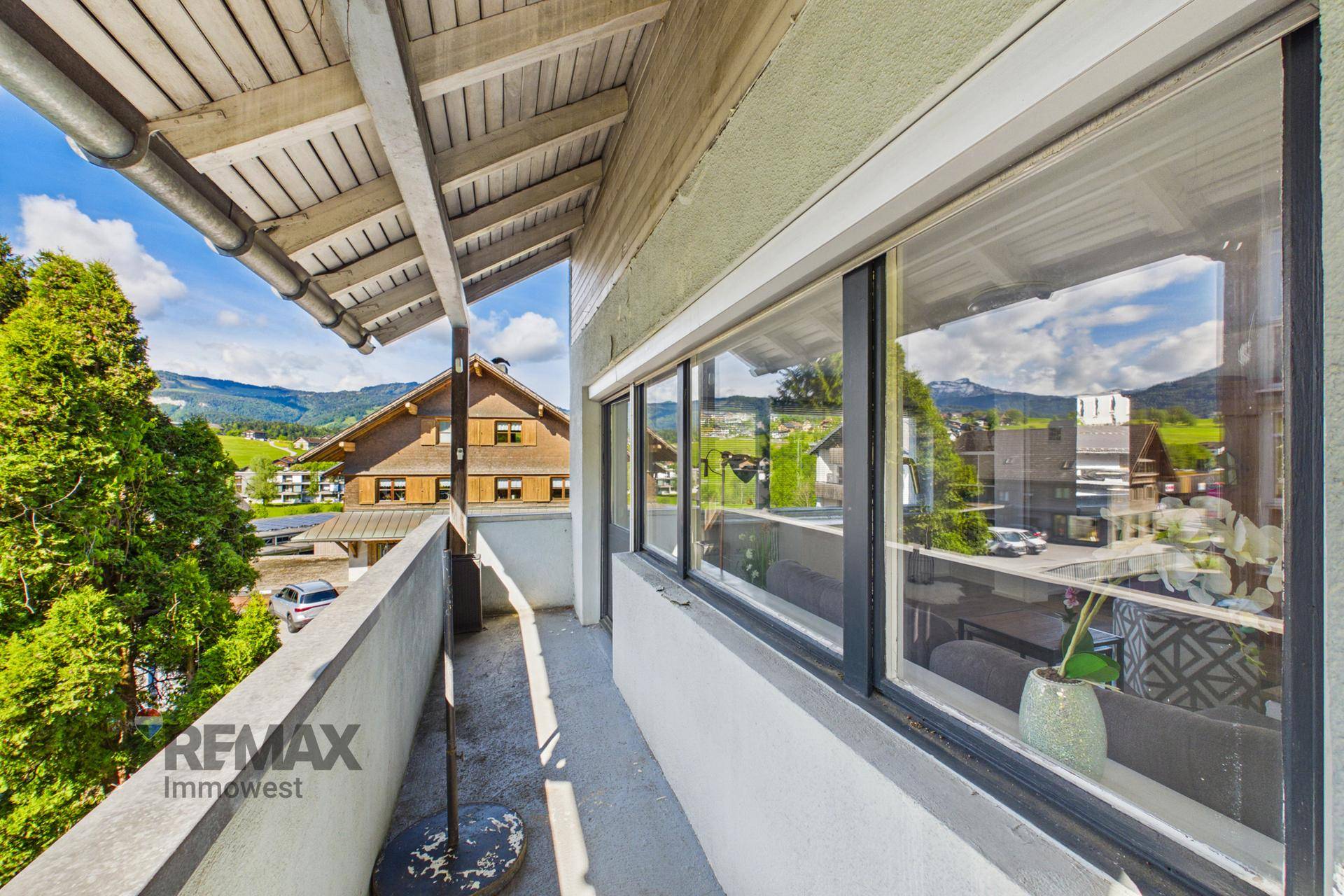 Balkon mit weitem Blick auf die Berge und die umliegende Landschaft an einem sonnigen Tag.