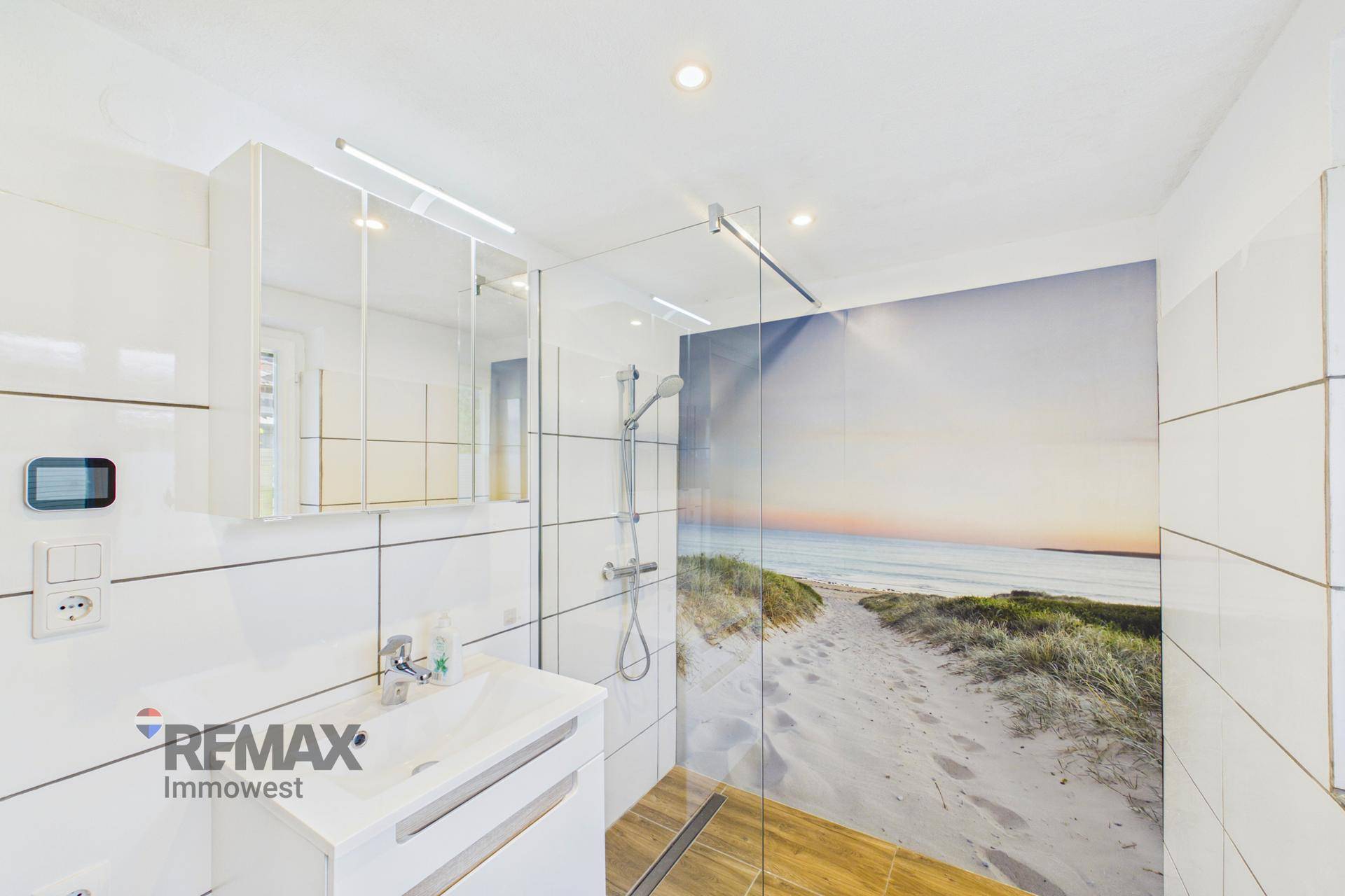 Modernes Badezimmer mit Dusche, Waschbecken und dekorativer Strandwand.