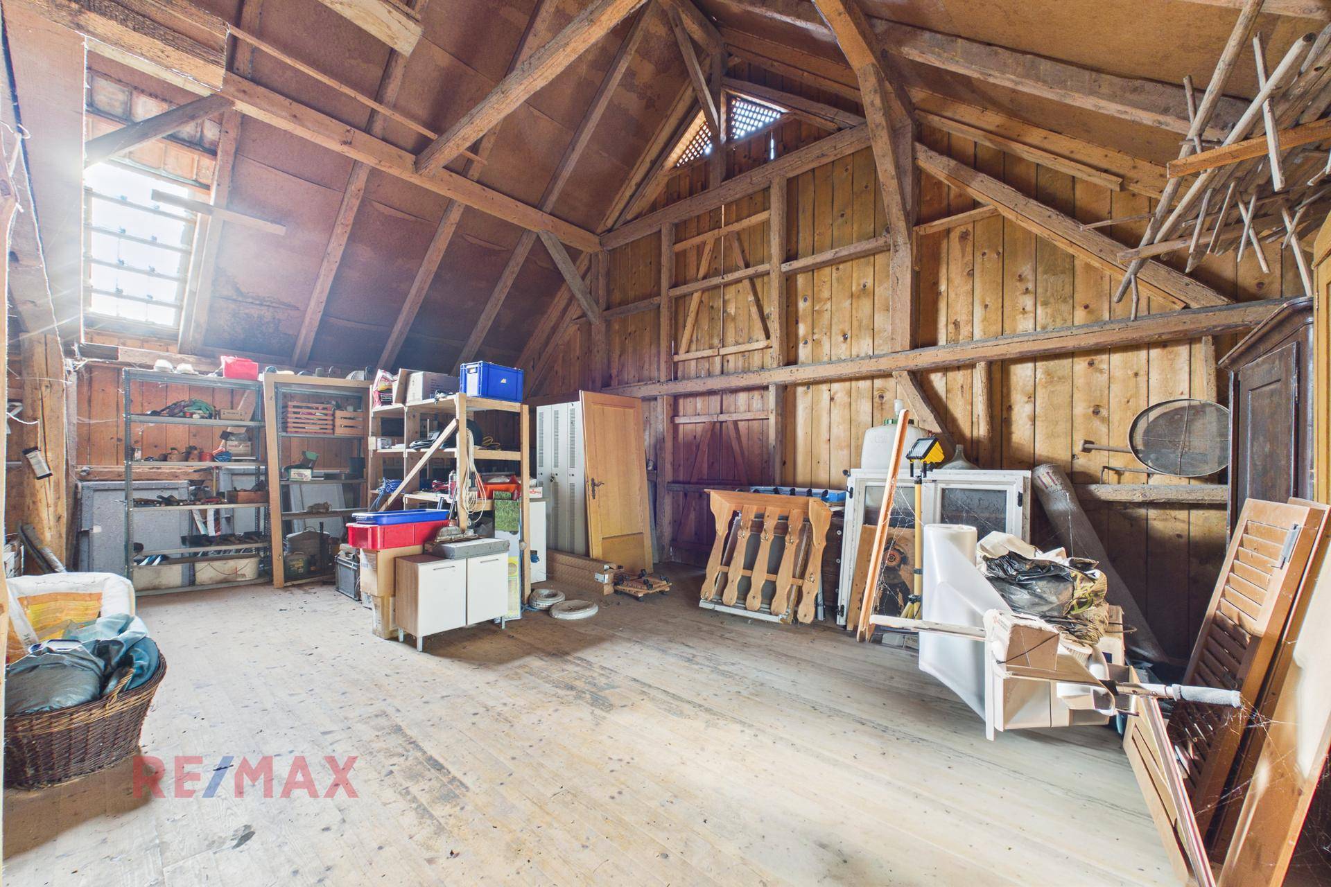 Geräumiger Dachboden mit sichtbaren Holzbalken und Holzverkleidung, ideal als Lagerfläche nutzbar.