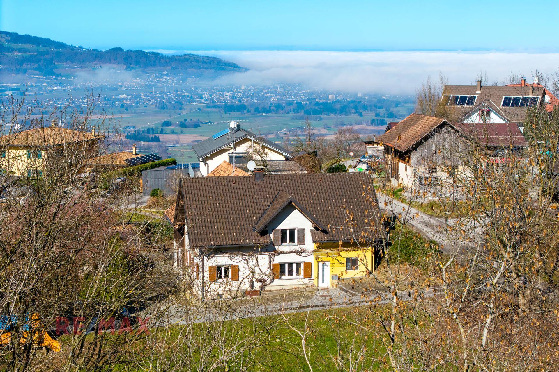 Ansicht des Wohnhauses mit traditioneller Architektur und Blick auf das nebelverhangene Tal.