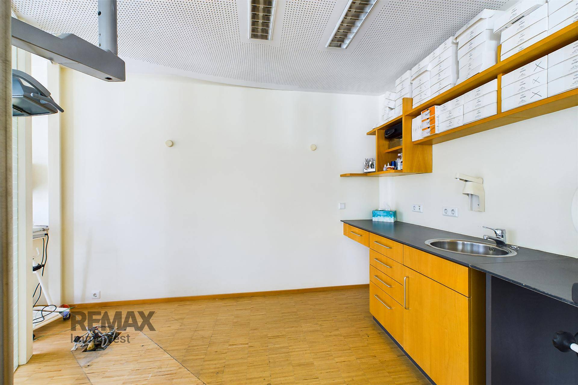 Büroraum mit Waschbecken, Unterschränken und Regalen, ideal für medizinische oder Laborzwecke.