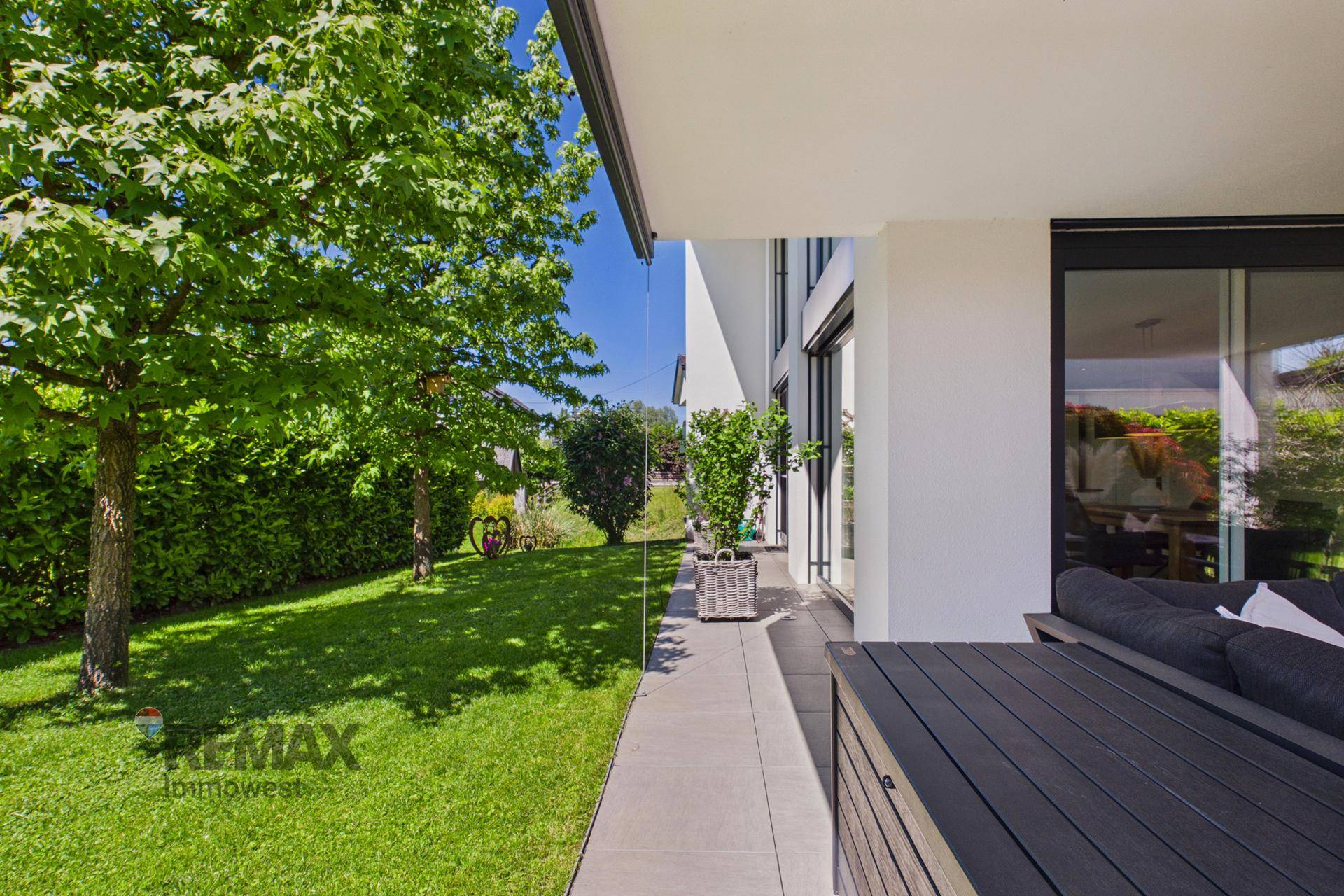 Sonnige Terrasse mit Gartenmöbeln und direktem Zugang zum weitläufigen Garten.