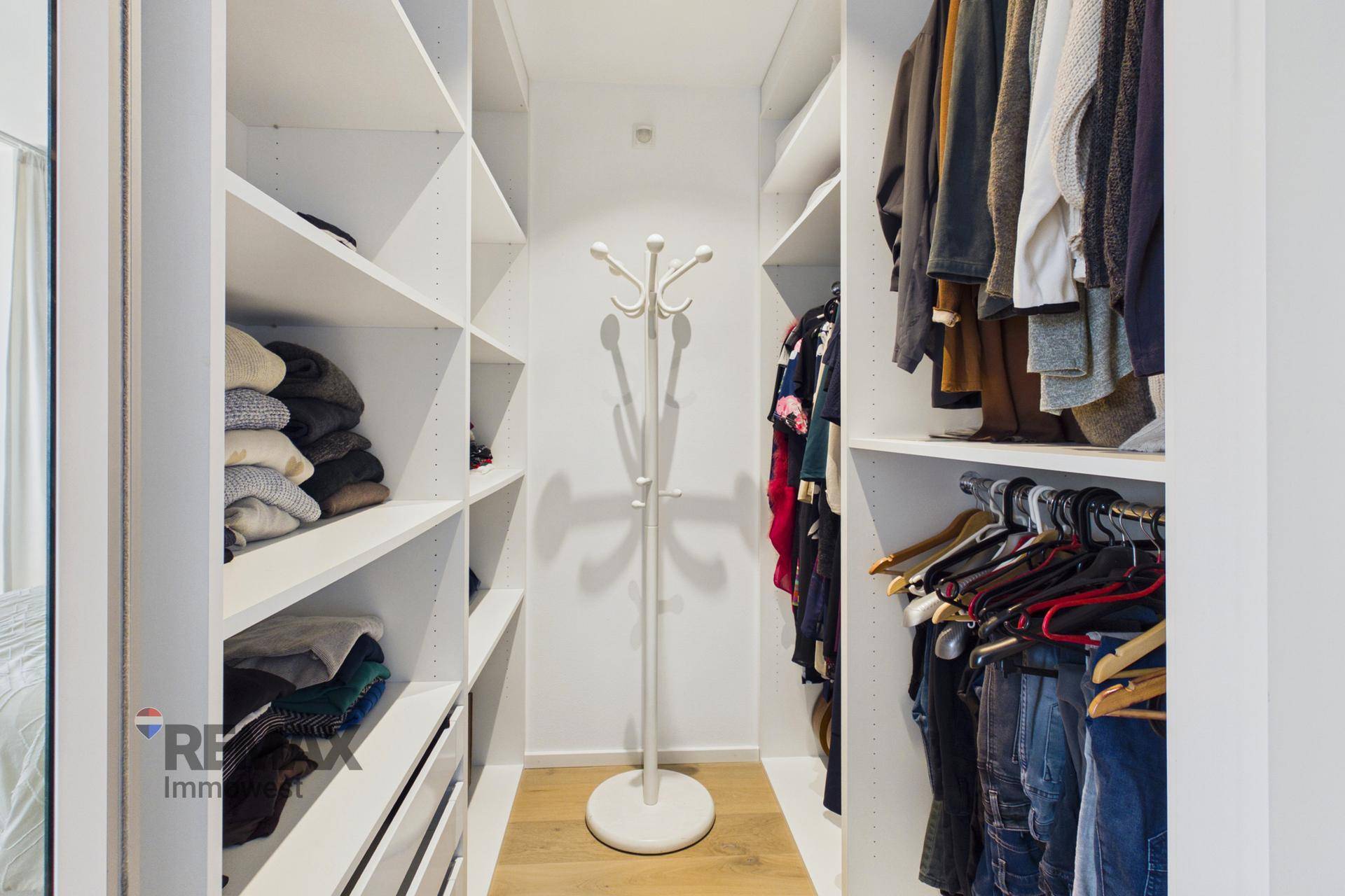Praktischer begehbarer Kleiderschrank mit Regalen und viel Stauraum für Kleidung.