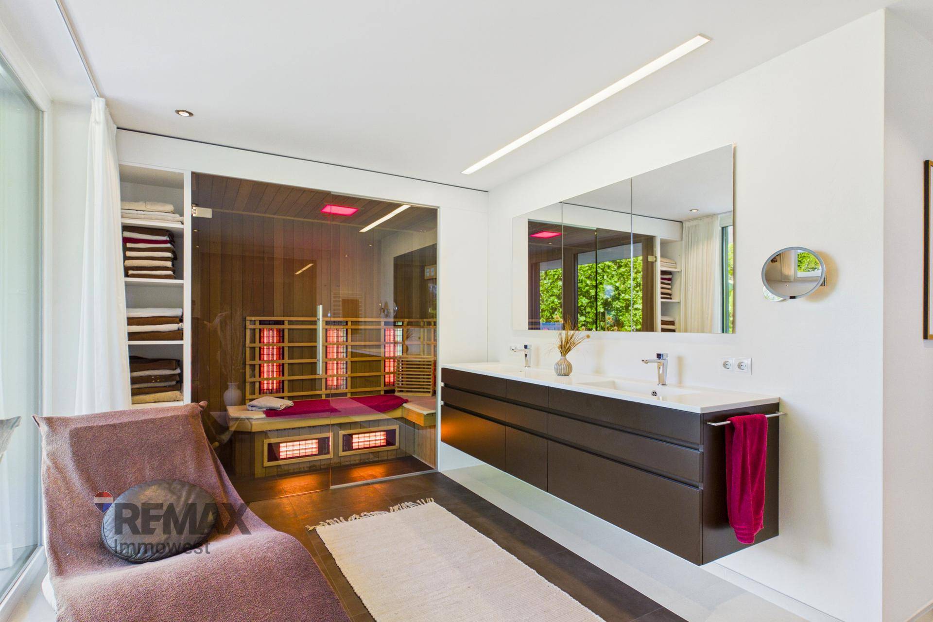 Luxuriöses Badezimmer mit Doppelwaschbecken, Spiegelschrank und integrierter Sauna.