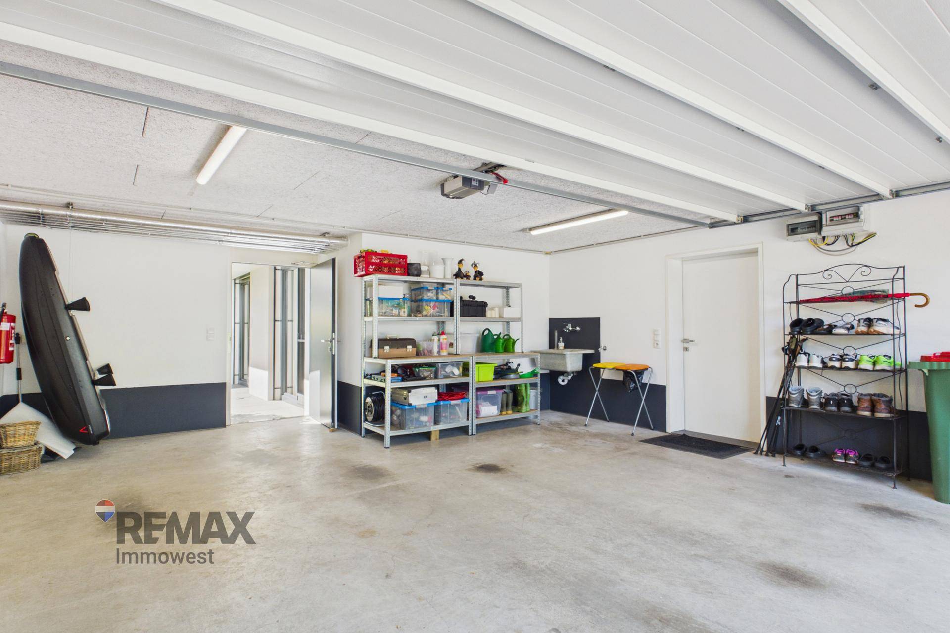Geräumige Garage mit viel Stauraum, Regalen und direktem Zugang zum Haus.