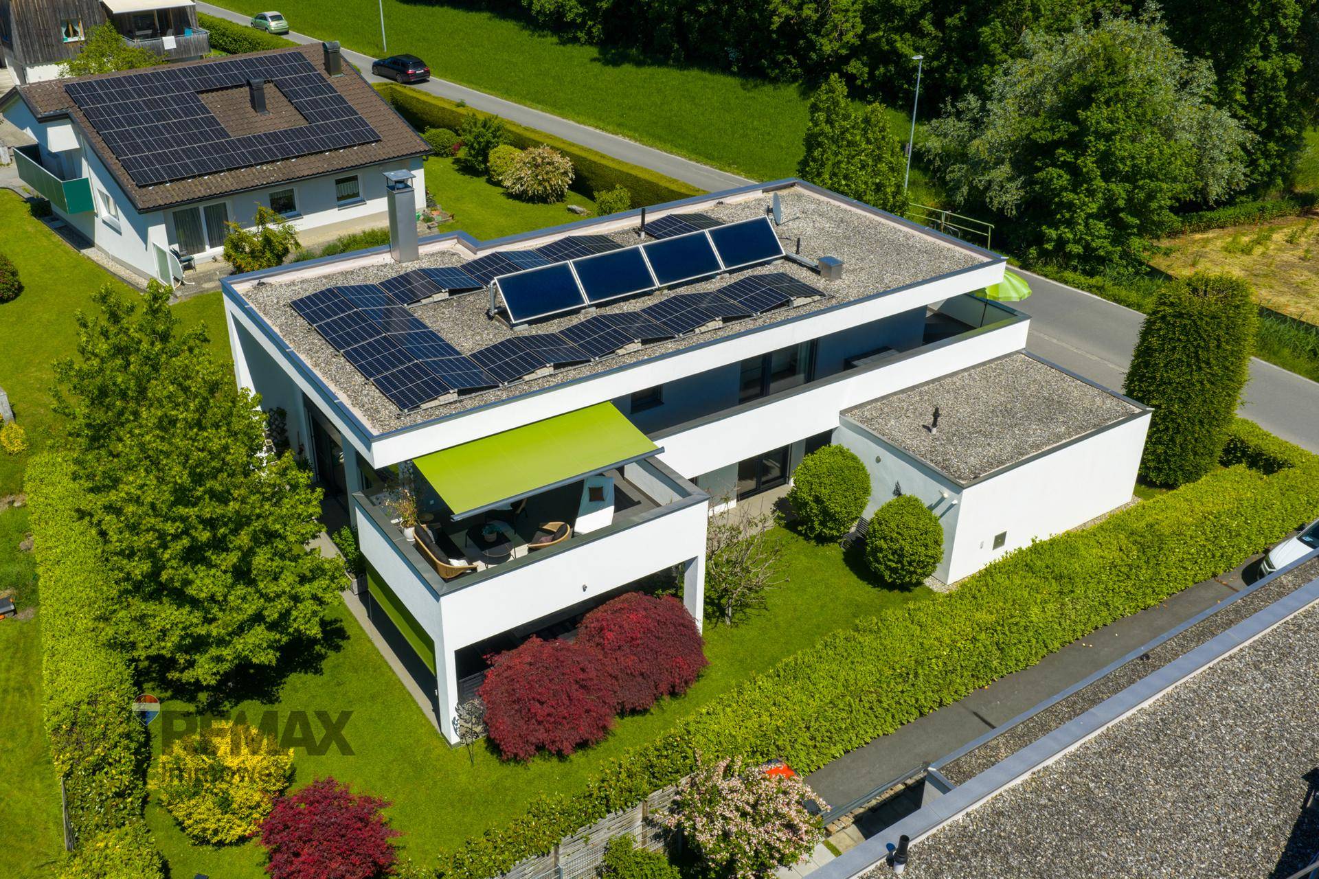 Vogelperspektive des Hauses mit Solaranlage, Terrasse und üppiger Bepflanzung im Garten.
