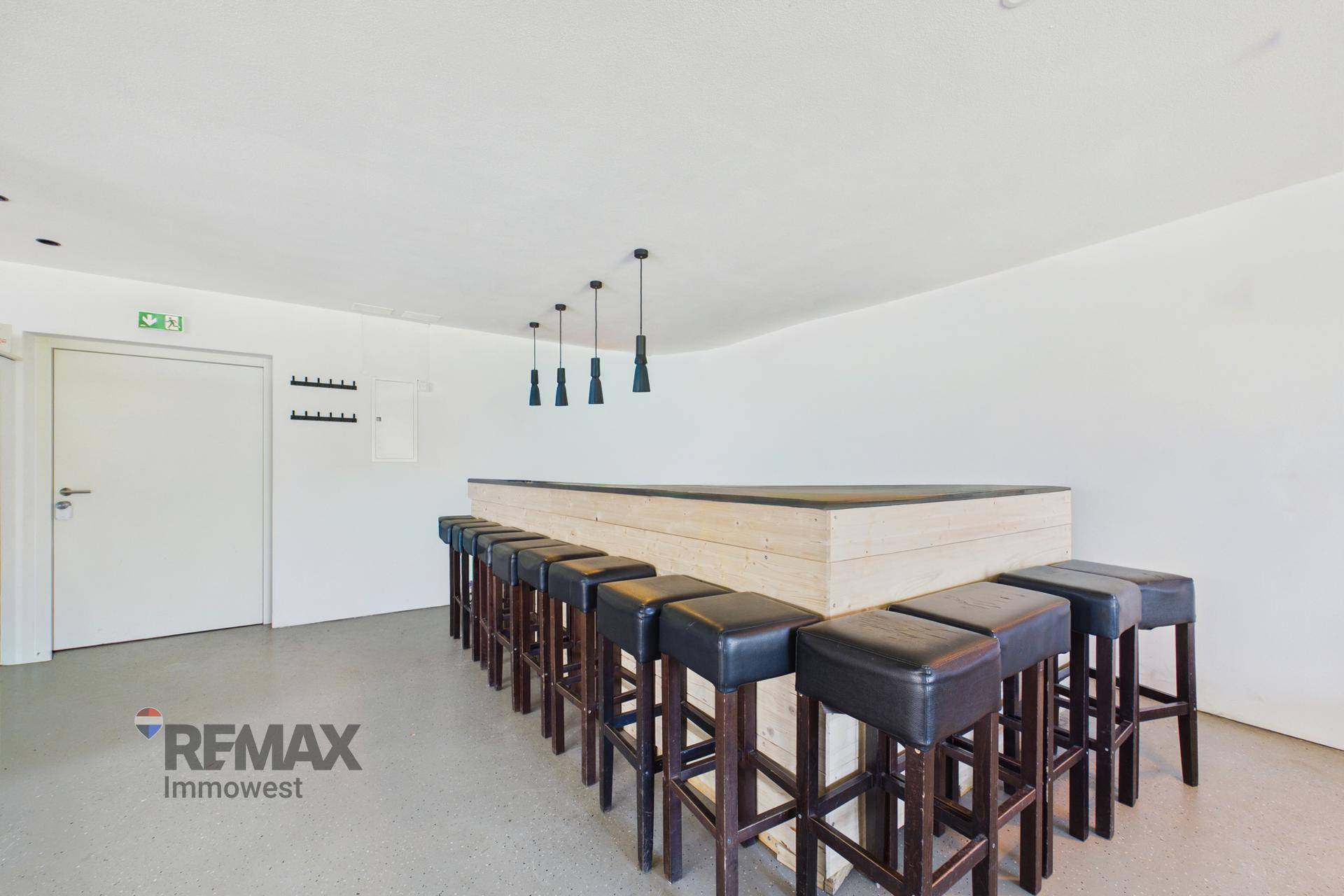 Bar-Bereich mit zahlreichen Hockern und einer Holztheke, ideal für gesellige Zusammenkünfte.