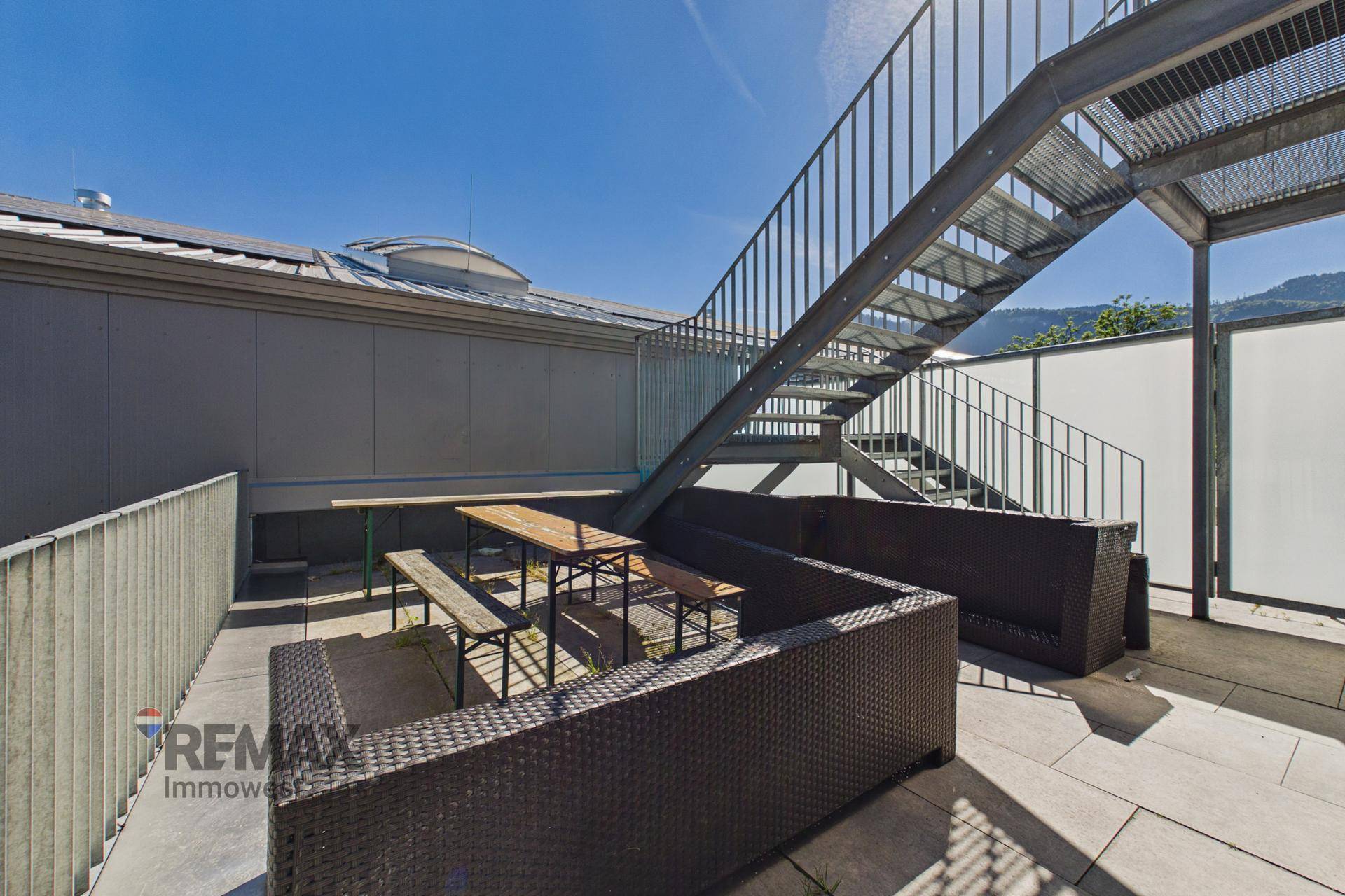 Terrasse mit Außentreppe und Sitzgelegenheiten, ideal für entspannte Stunden im Freien.