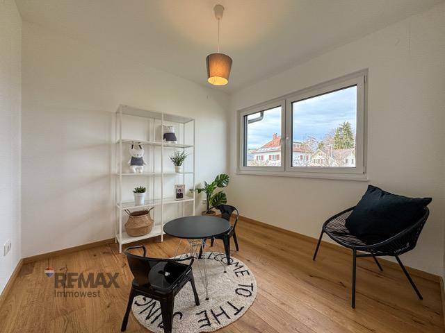 Helles Zimmer mit Holzboden, Fenster und moderner Einrichtung, ideal als Büro.