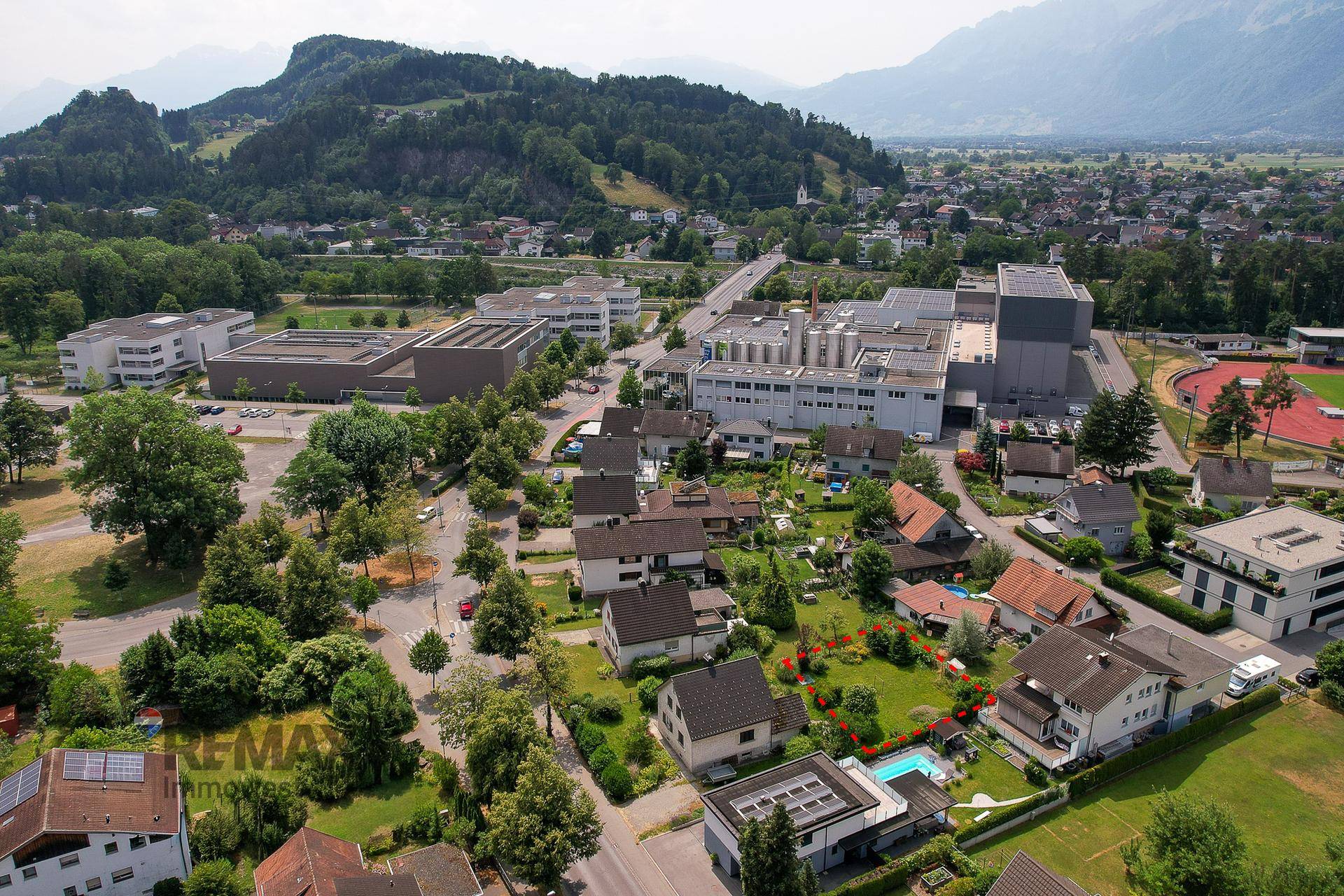 Weitläufige Luftaufnahme der Stadt und Umgebung mit Bergen im Hintergrund.