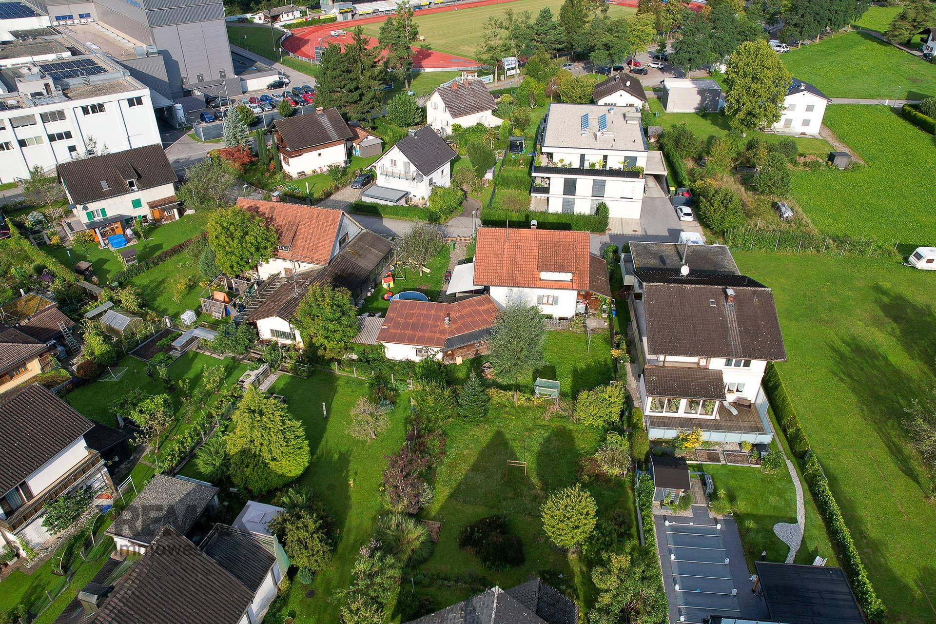 Panoramablick aus der Luft auf die Wohngegend mit vielen Grünflächen und Gebäuden.
