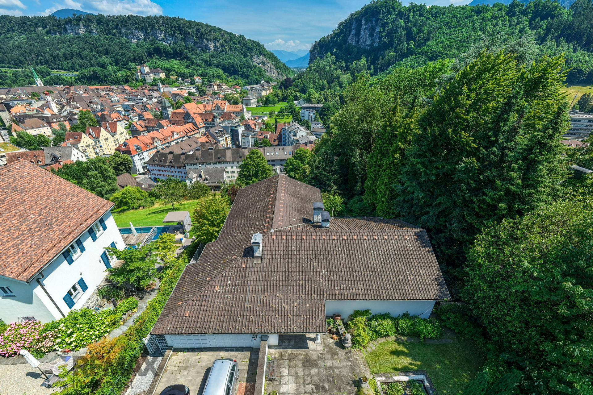 Dachansicht des Hauses mit Blick auf die umliegende Stadt und die beeindruckende Berglandschaft.