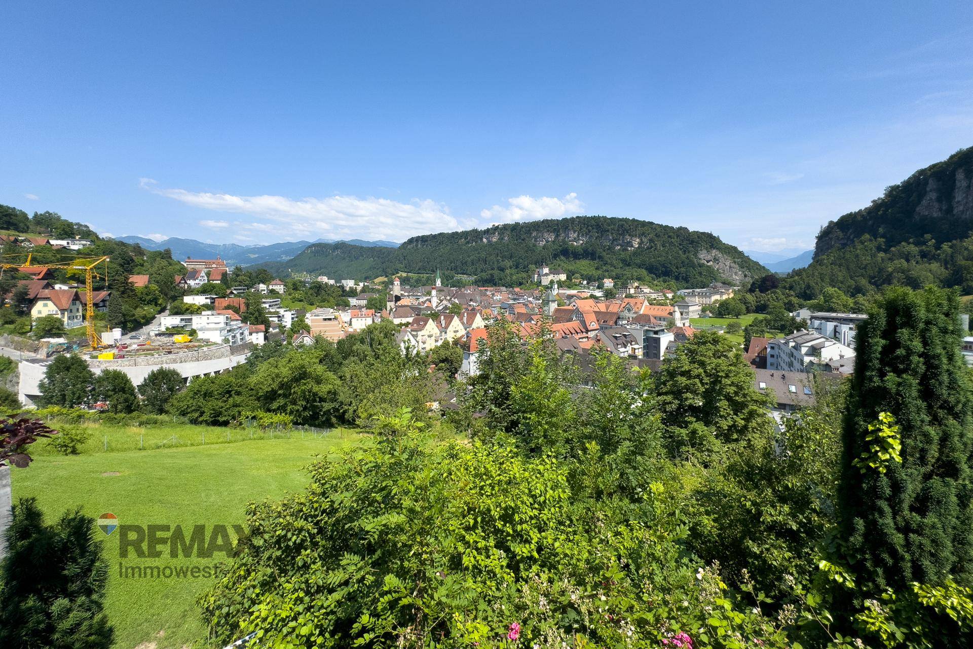 Panoramablick auf die Stadt und die majestätischen Berge von der erhöhten Lage des Anwesens.