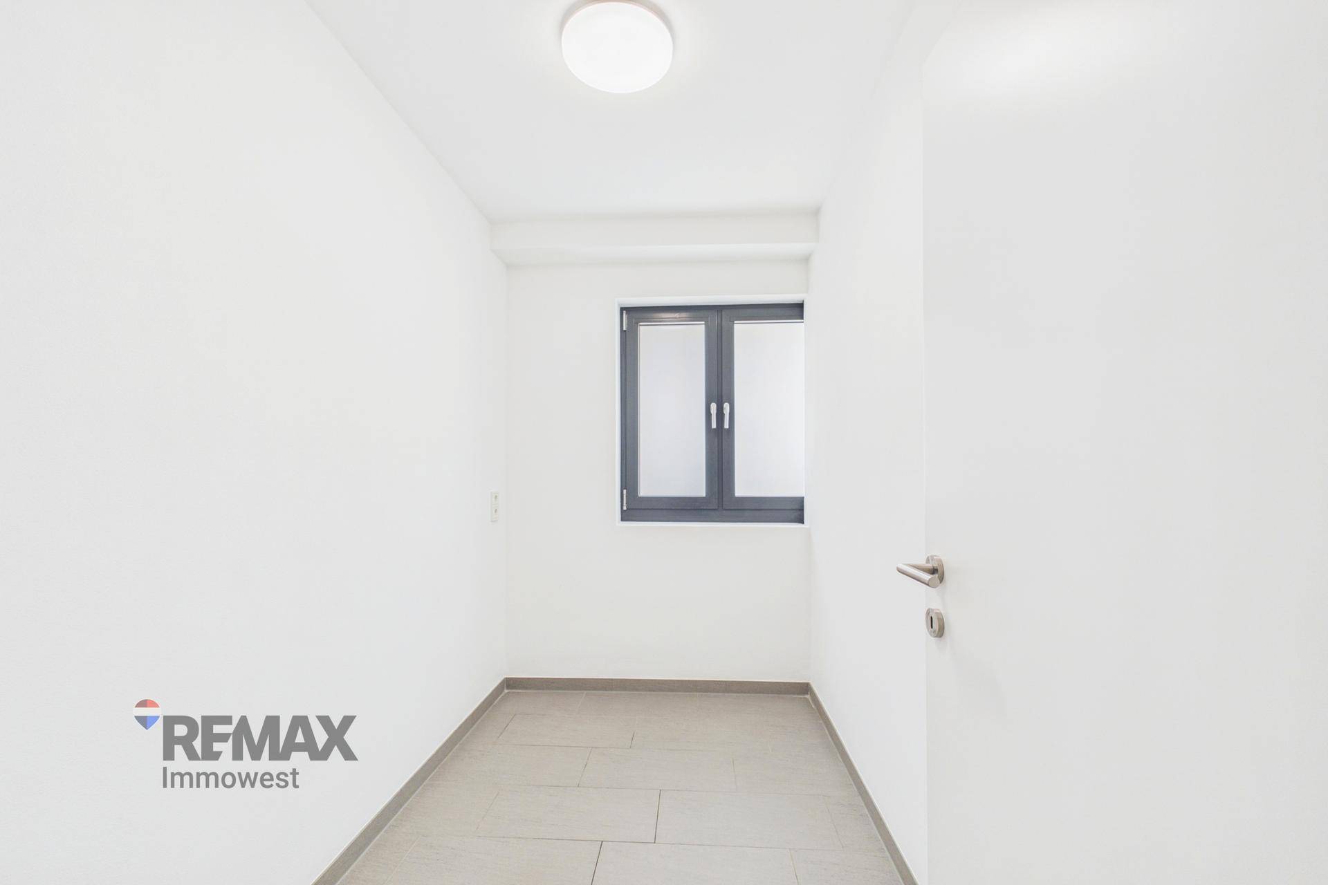 Kleiner, heller Raum mit Fliesenboden und einem Fenster, ideal als Abstellraum oder Büro.