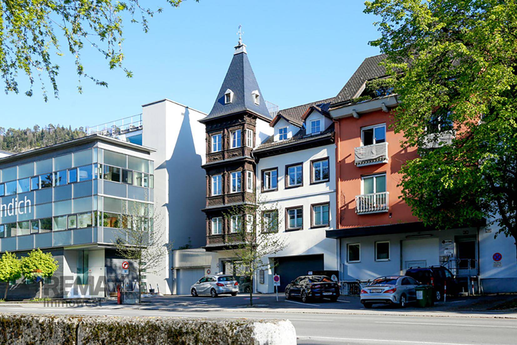 Stadtansicht mit verschiedenen Gebäuden, darunter ein historischer Erkerbau.