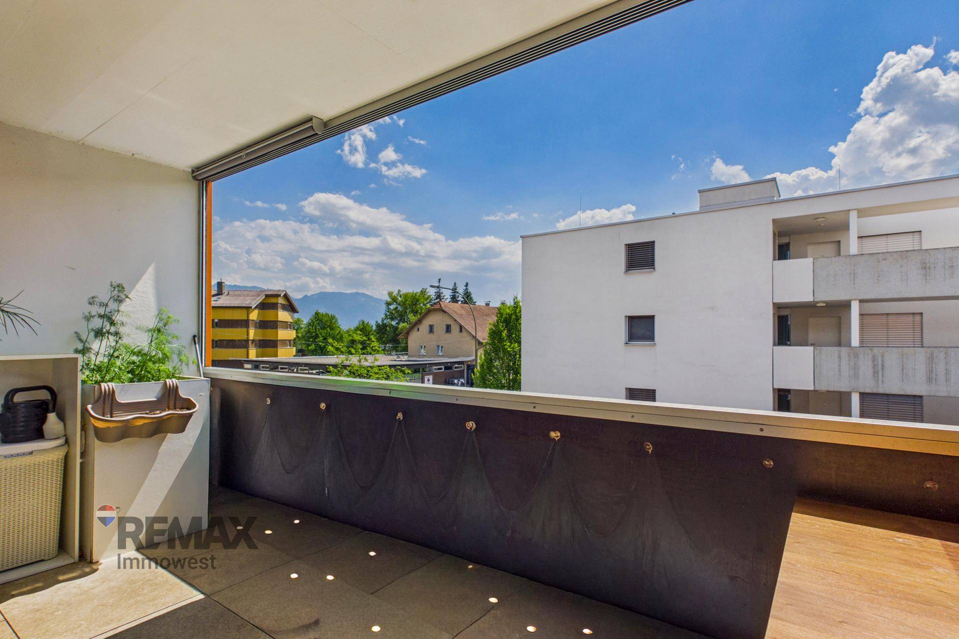 Heller Balkon mit Bergblick und teilweiser Verglasung für zusätzlichen Komfort.