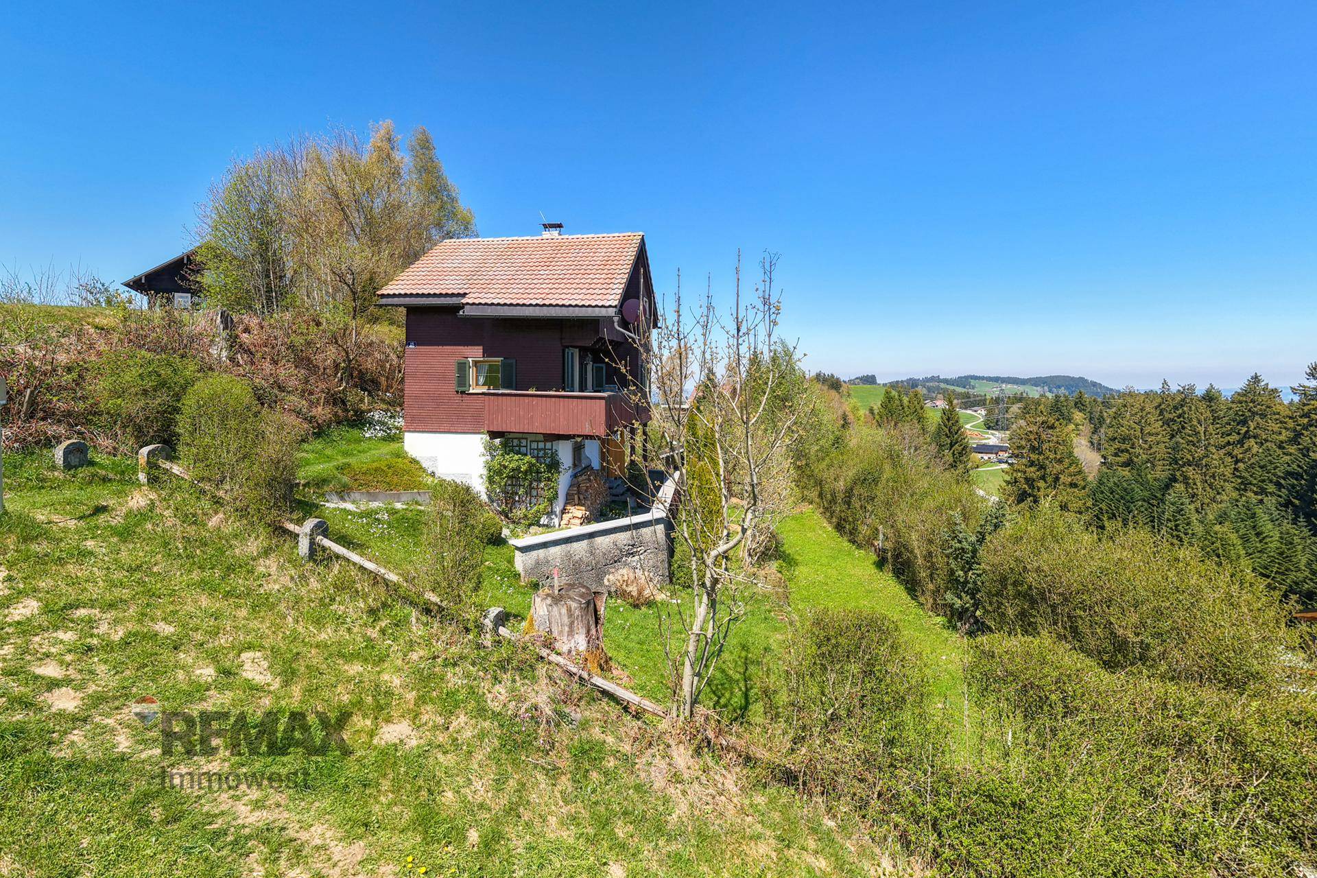 Ländliches Haus in idyllischer Lage mit weitem Blick über grüne Hügel und Wälder.