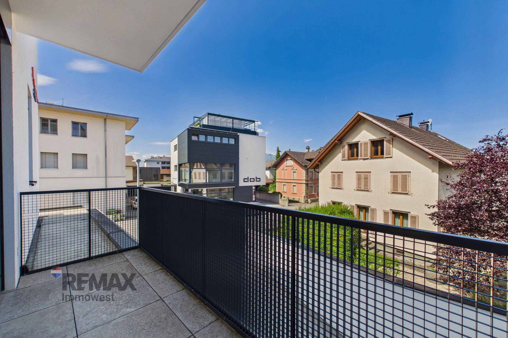 Balkon mit Fliesenboden und Metallgeländer, bietet einen weiten Blick auf die Umgebung und Berge.