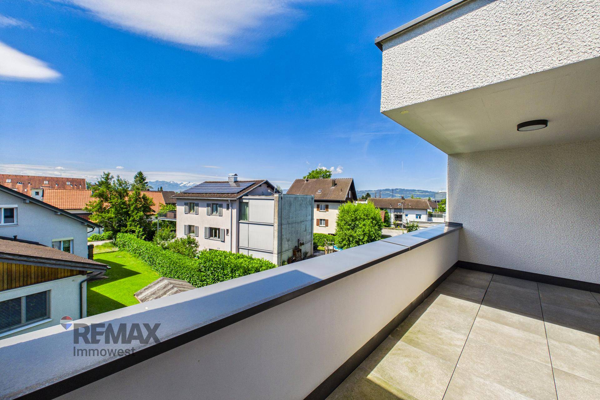 Balkon mit weitem Blick über die Dächer der Nachbarschaft und die entfernten Berge.